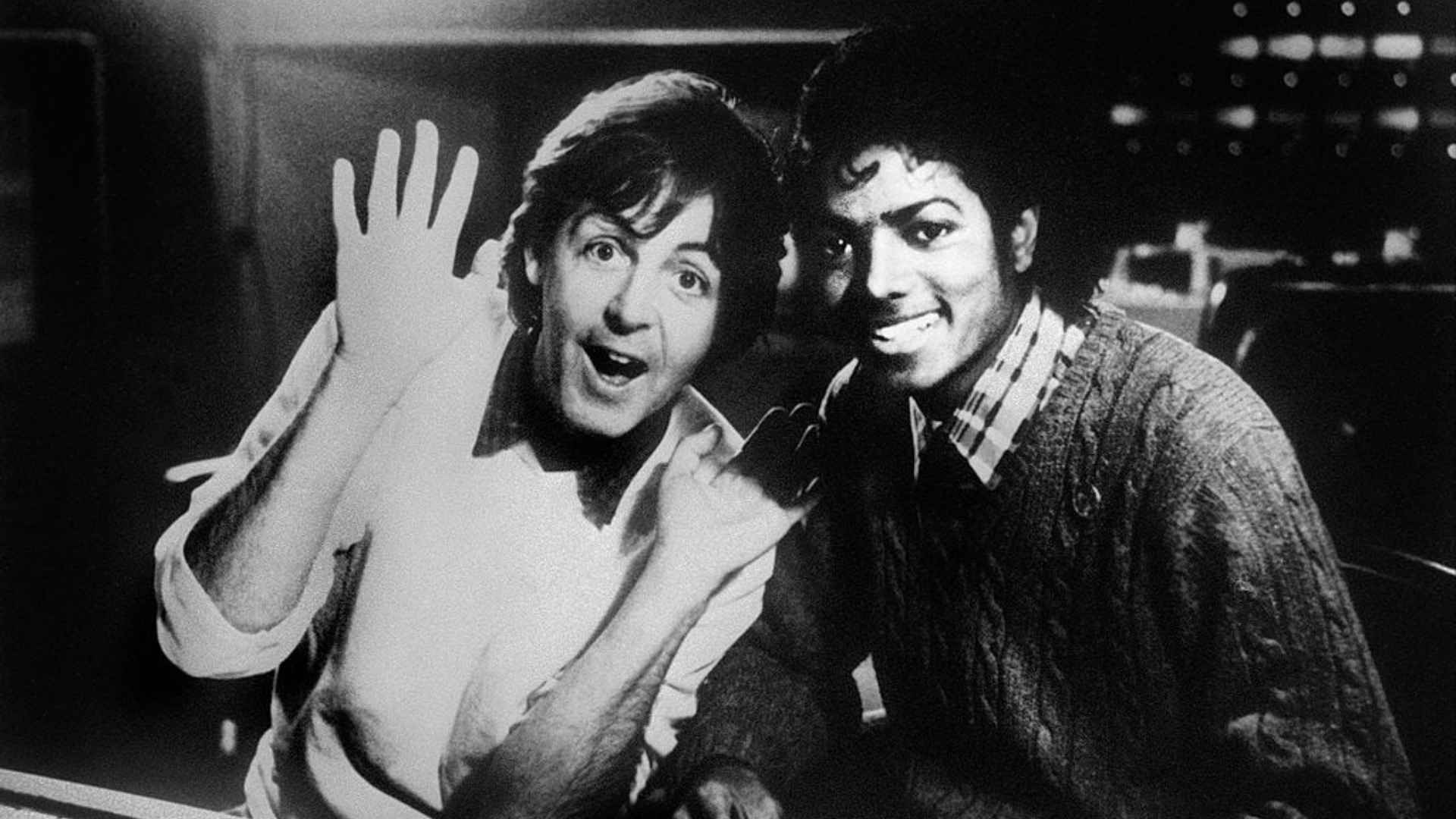 Paul McCartney and Michael Jackson smiling together in a black and white photo.