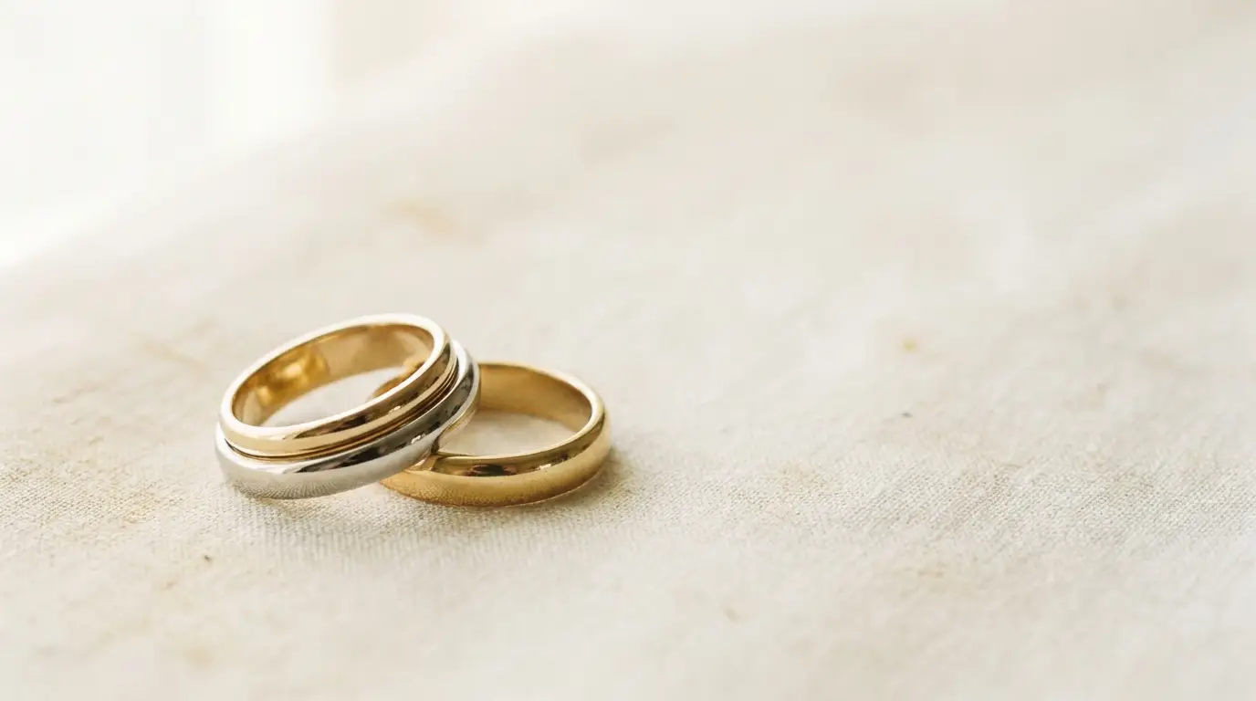 Two gold rings on soft beige fabric in natural light