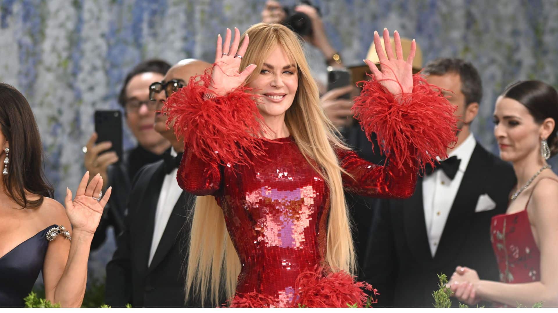 Nicole Kidman wearing a sparkling red Balenciaga gown with feathered cuffs at the Met Gala