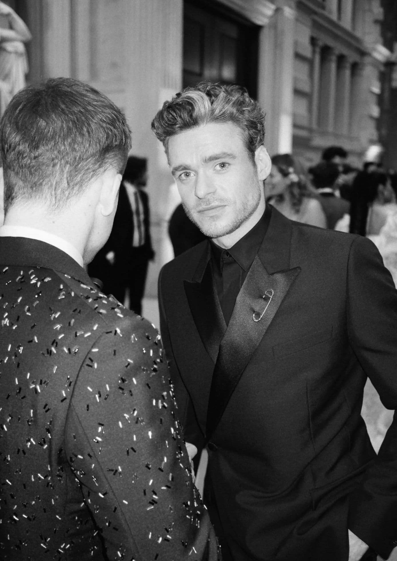 Richard Madden in a black tuxedo with a beaded suit guest, captured at the event. (1)