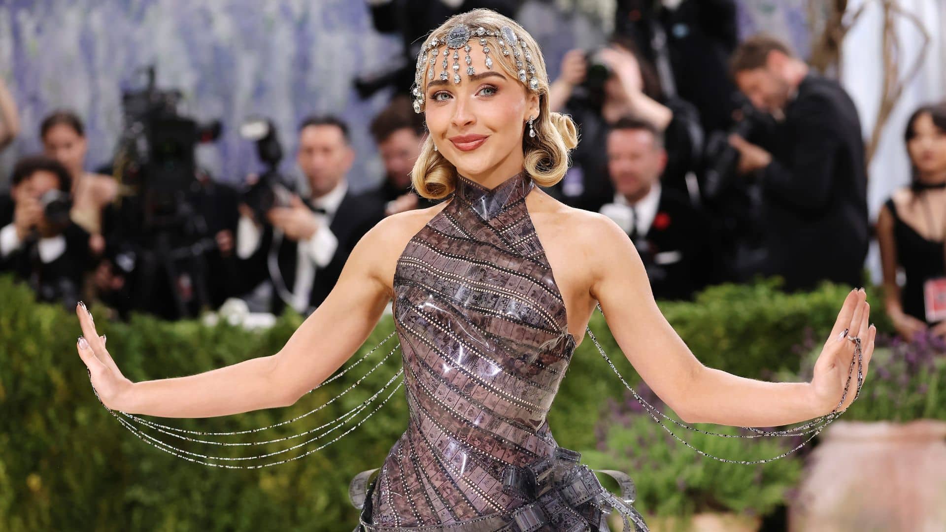 Sabrina Carpenter wearing a vintage-inspired Dior gown with crystal chains and jeweled headpiece