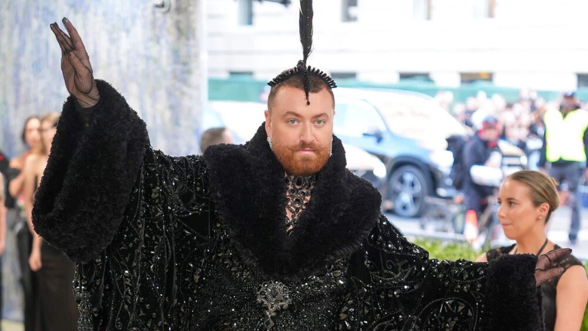 Sam Smith wearing a dramatic black Christian Cowan ensemble with embellished cape and sculptural headpiece