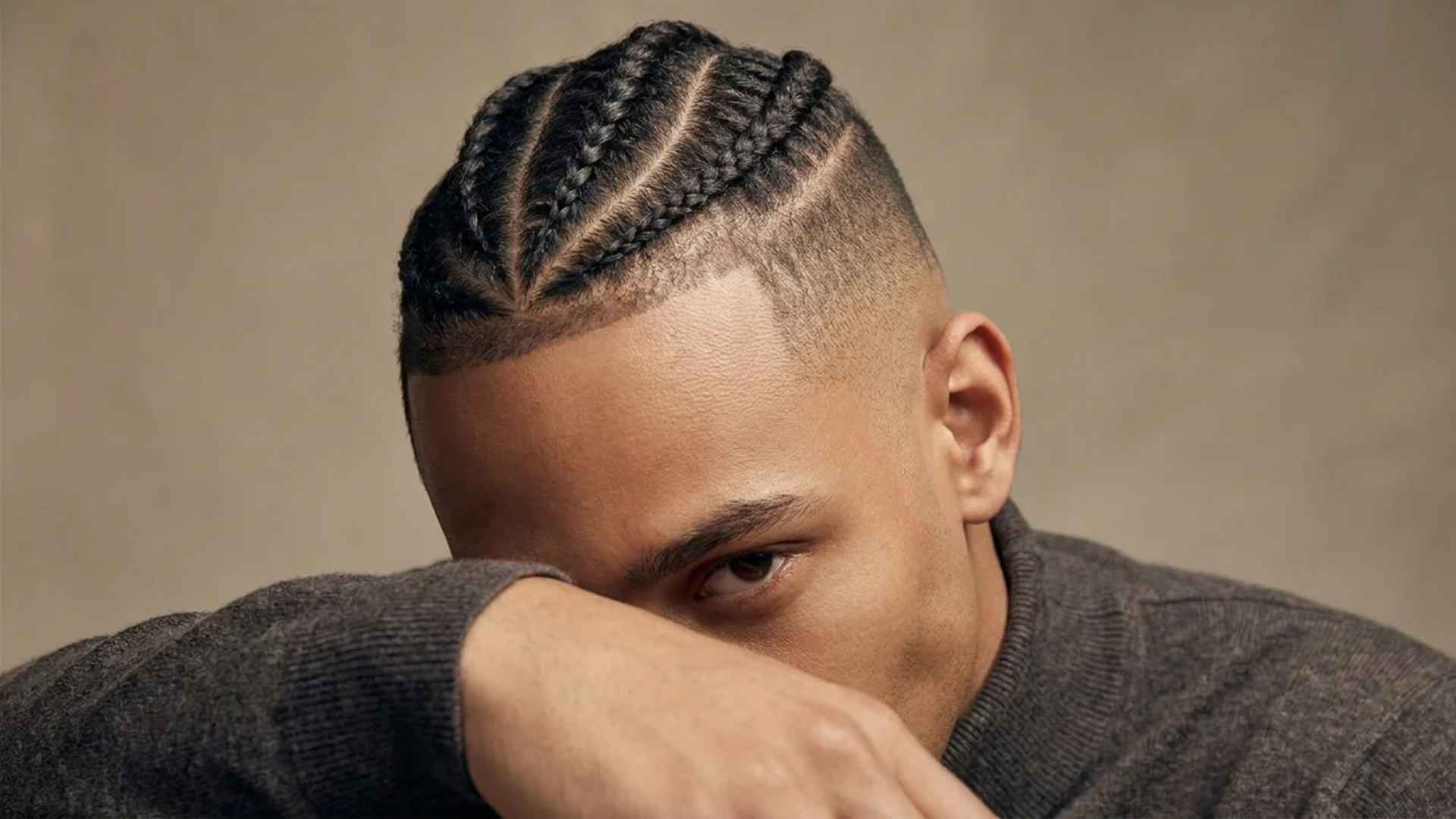 Neat cornrows on top meeting a crisp skin fade on shaved sides and temples.