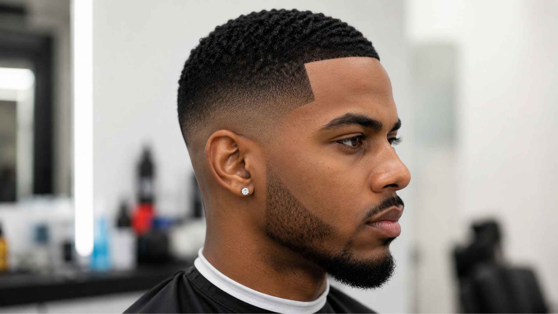 Skin fade with precise line-up hairline, sharp geometric edges on temples and forehead.