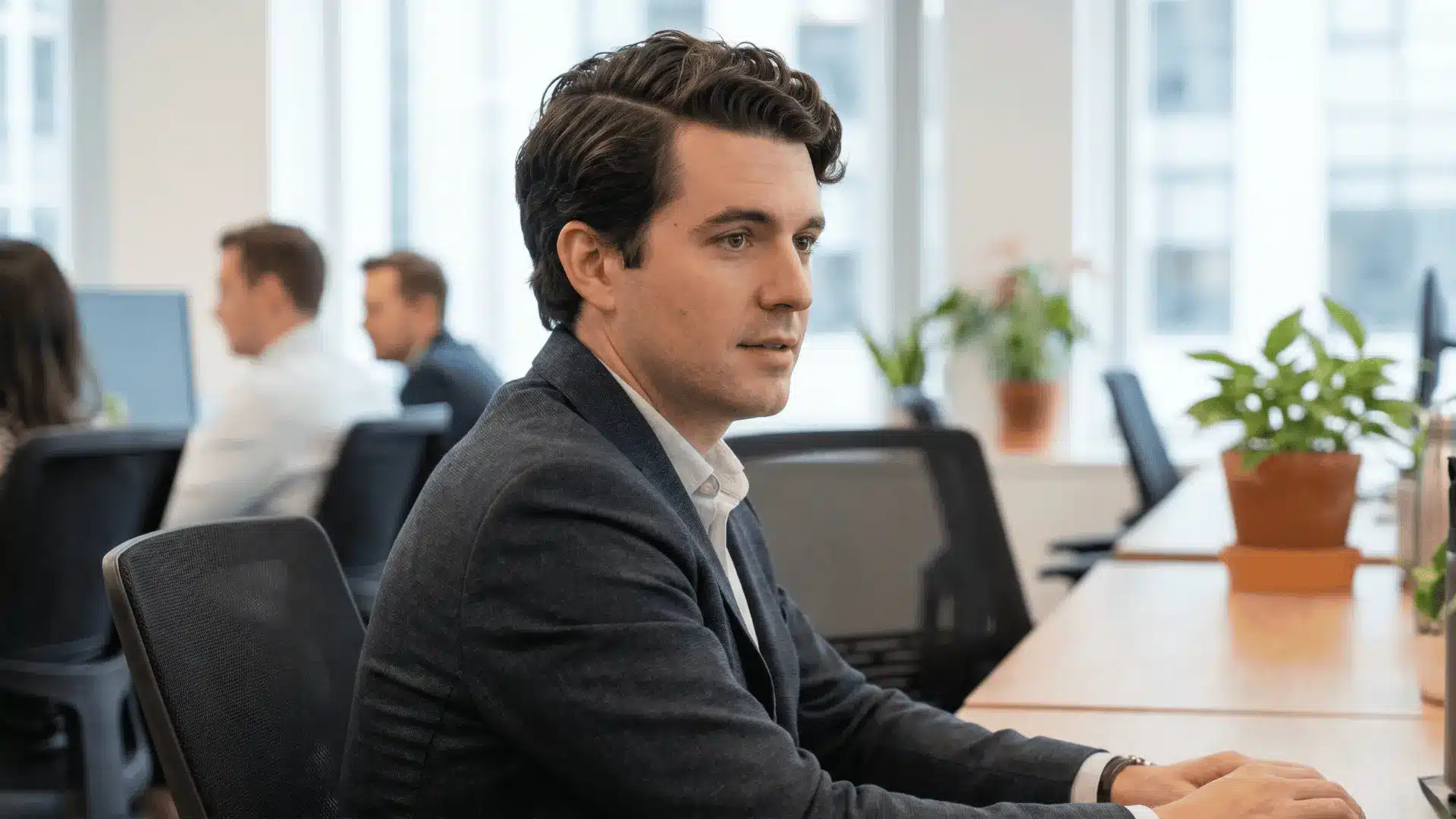 Handsome male model in an office with wavy side part hairstyle, hair parted neatly with visible waves