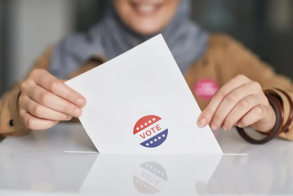 Ballot paper with vote sticker held by person in casual clothing at polling station