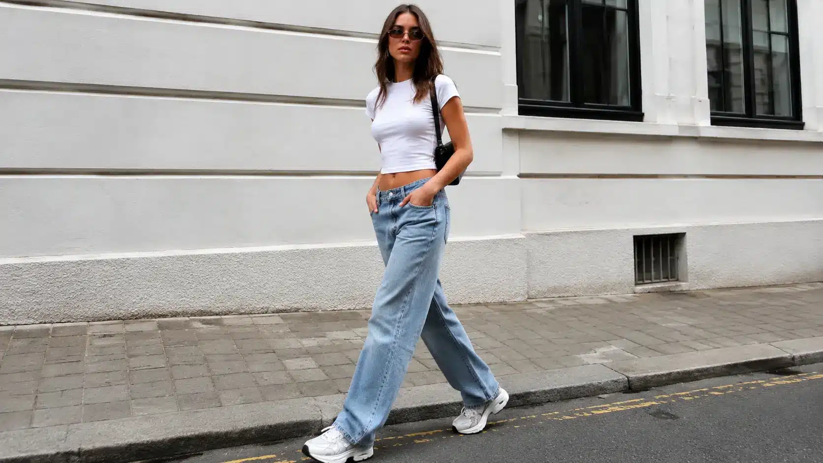 Woman in baggy jeans, white tee, and chunky sneakers
