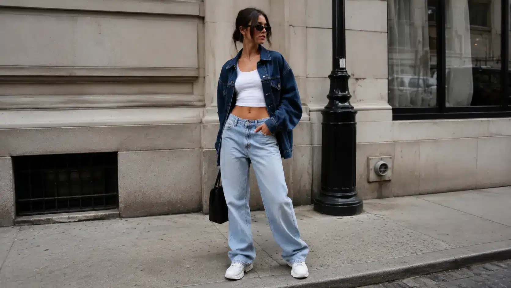 Woman wearing baggy jeans with crop top and denim jacket