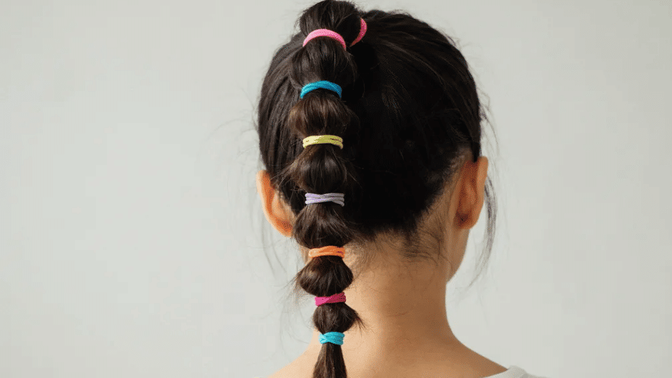 Bubble ponytail with colorful ties and bold sections, playful Y2K party hairstyle with fun early 2000s vibe look