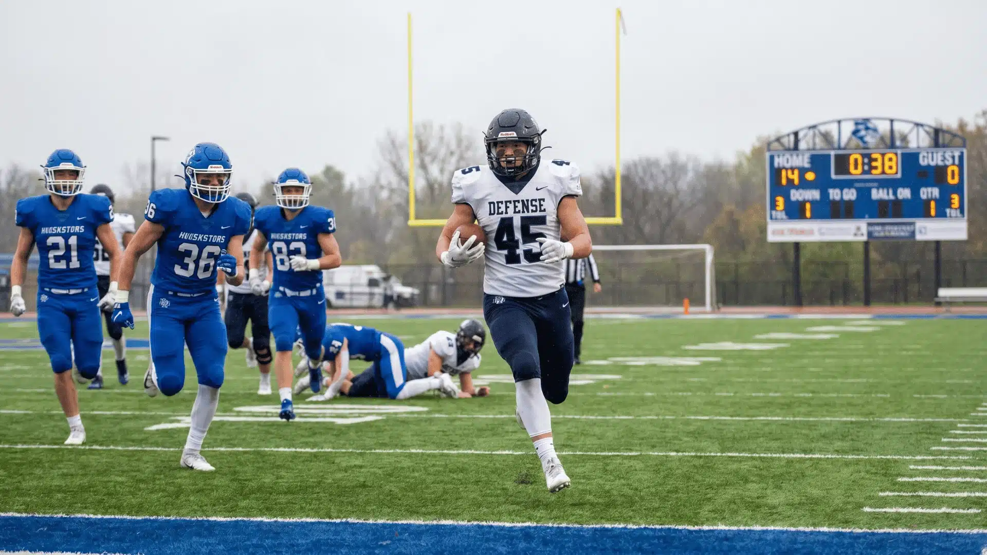 Defensive player returning a blocked PAT toward the end zone with pursuing opponents.