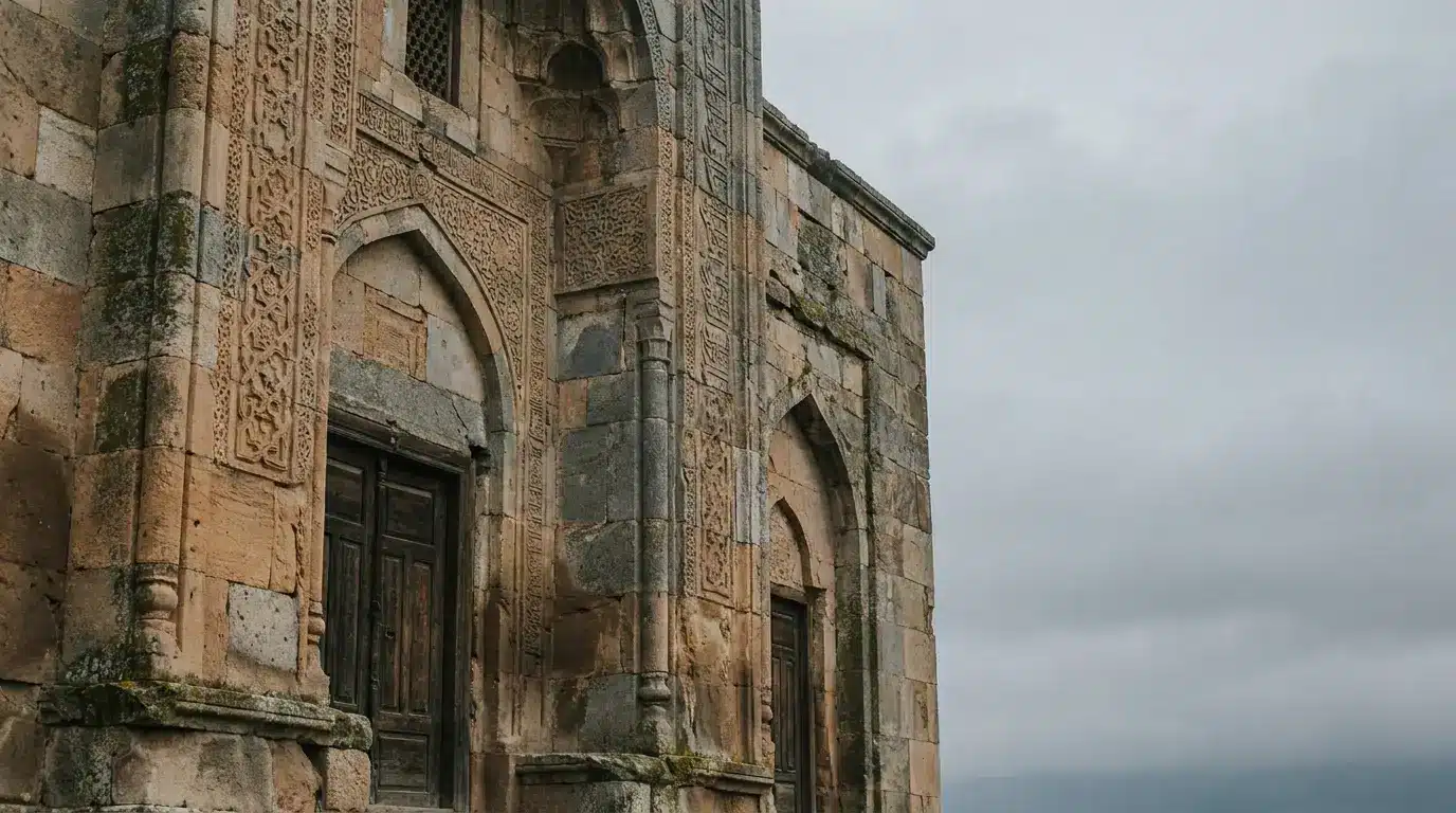 Stone facade of ancient building with intricate carvings under overcast sky