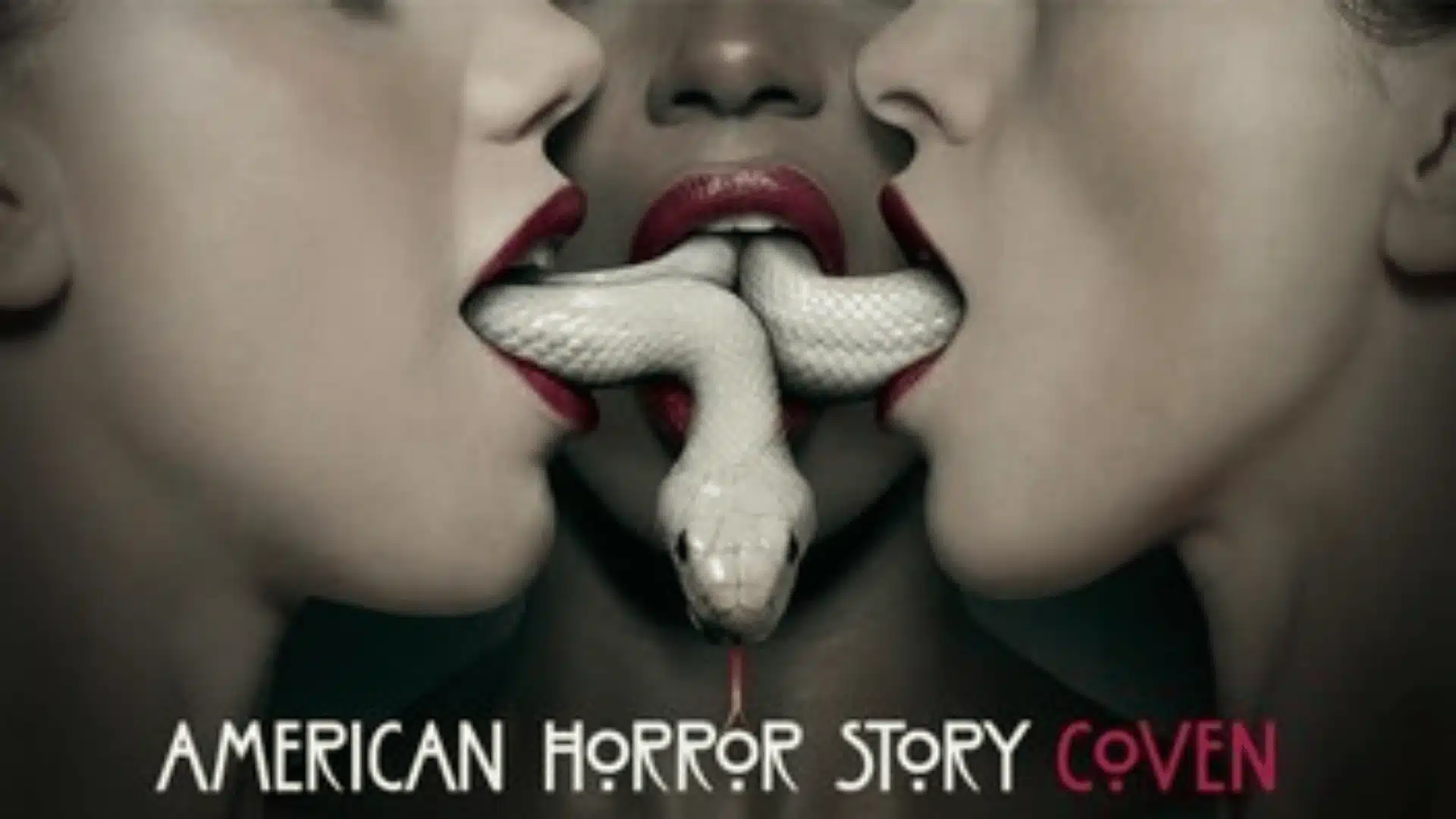 Three women’s faces close together with red lipstick, sharing a white snake between their mouths, American Horror Story Coven poster.