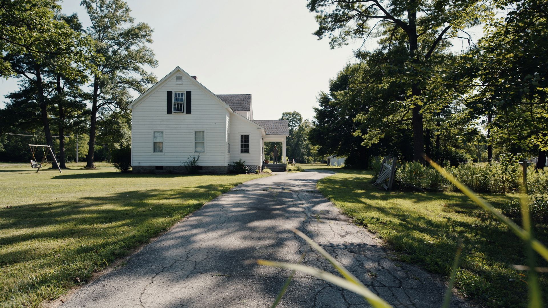 A cinematic still from *Get Out* showing a tense and unsettling moment between characters in a suburban home setting, capturing psychological suspense and emotional intensity.
