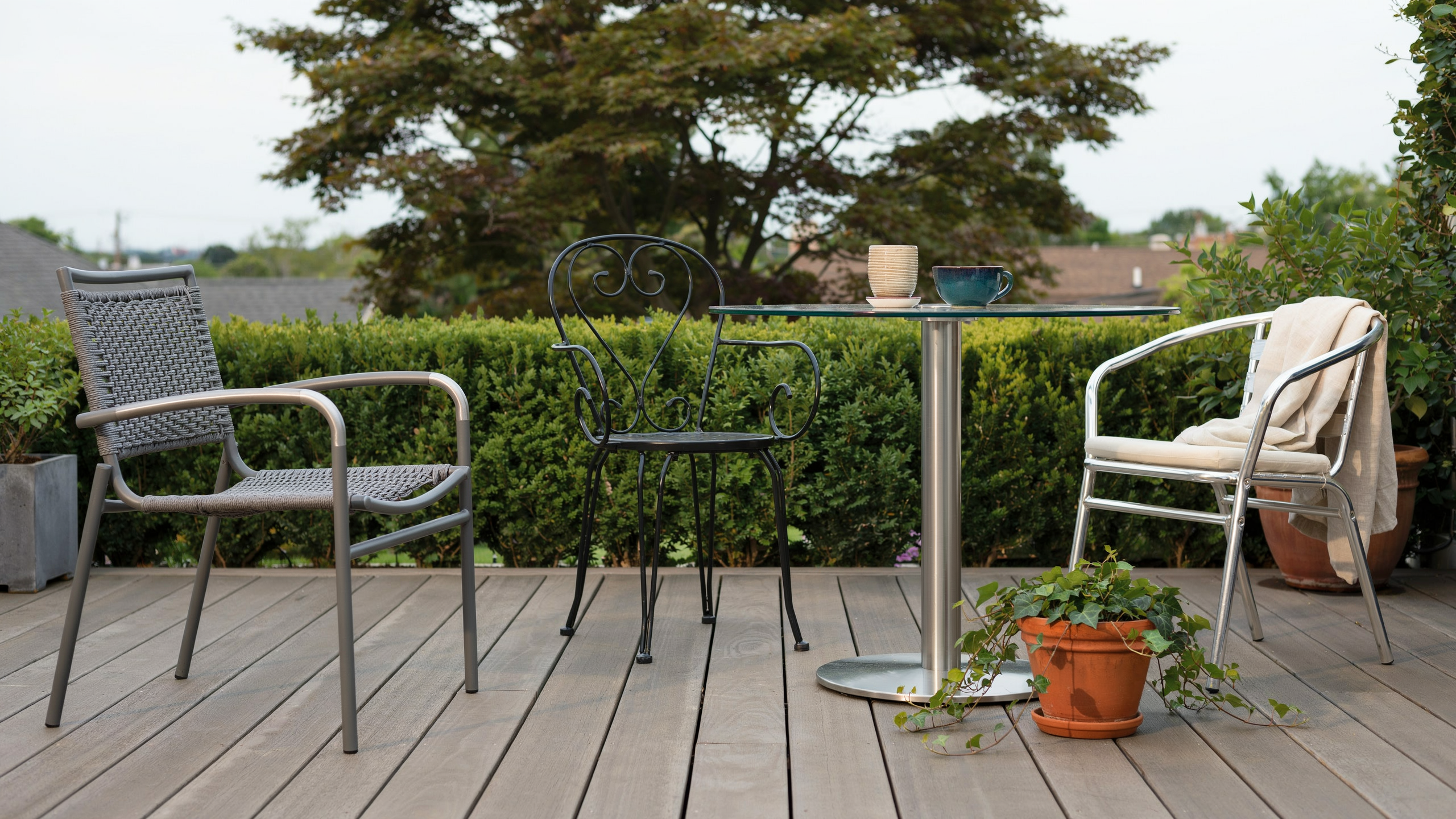 Shiny metal patio table and chairs on a deck, freshly cleaned