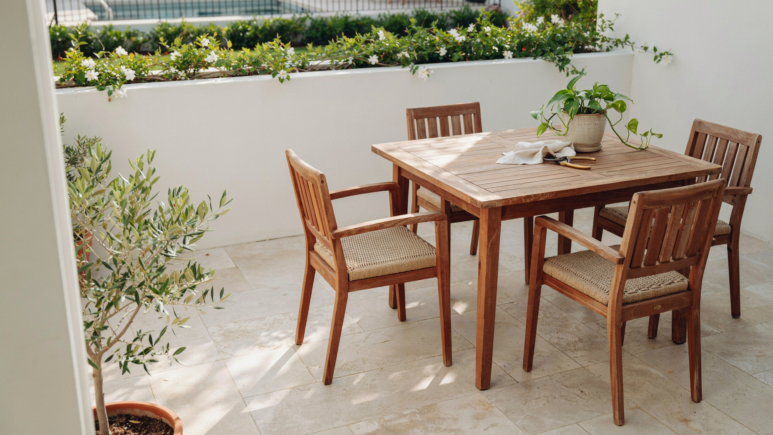Teak patio furniture naturally arranged on a sunny patio