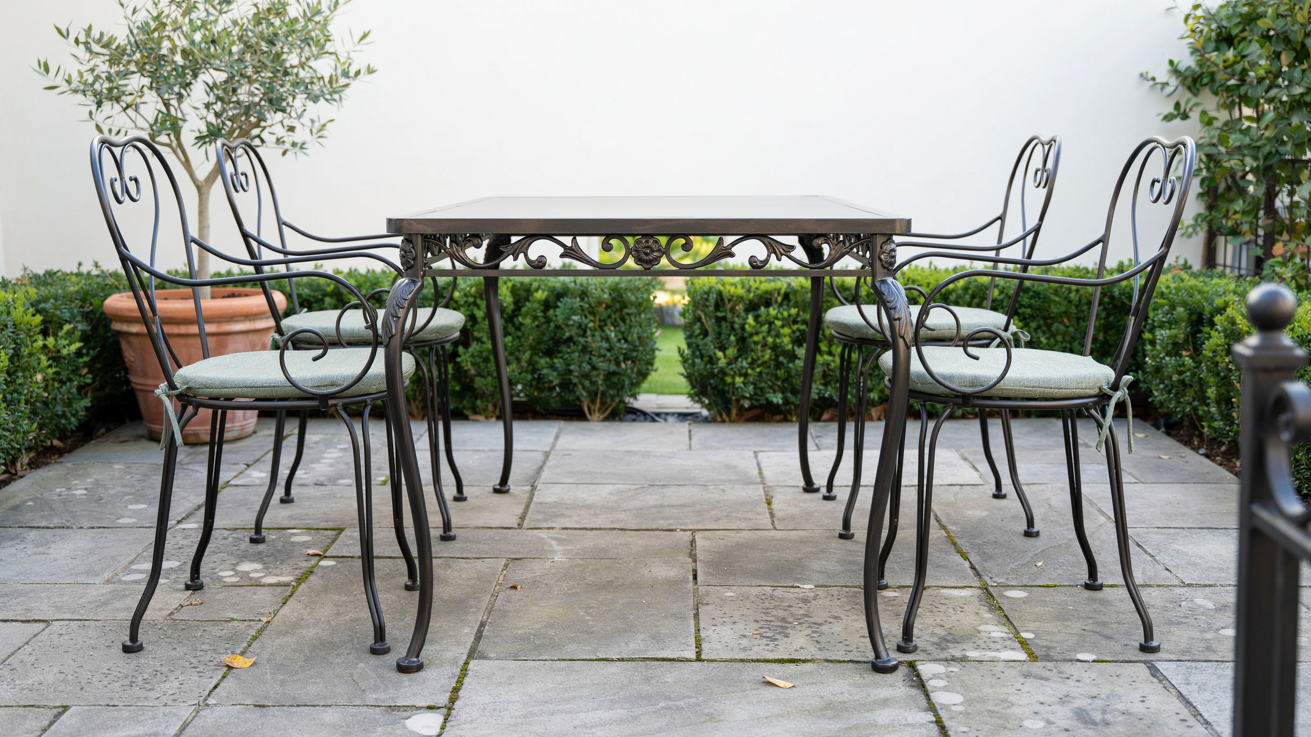Wrought iron patio table and chairs, realistically arranged, no people.