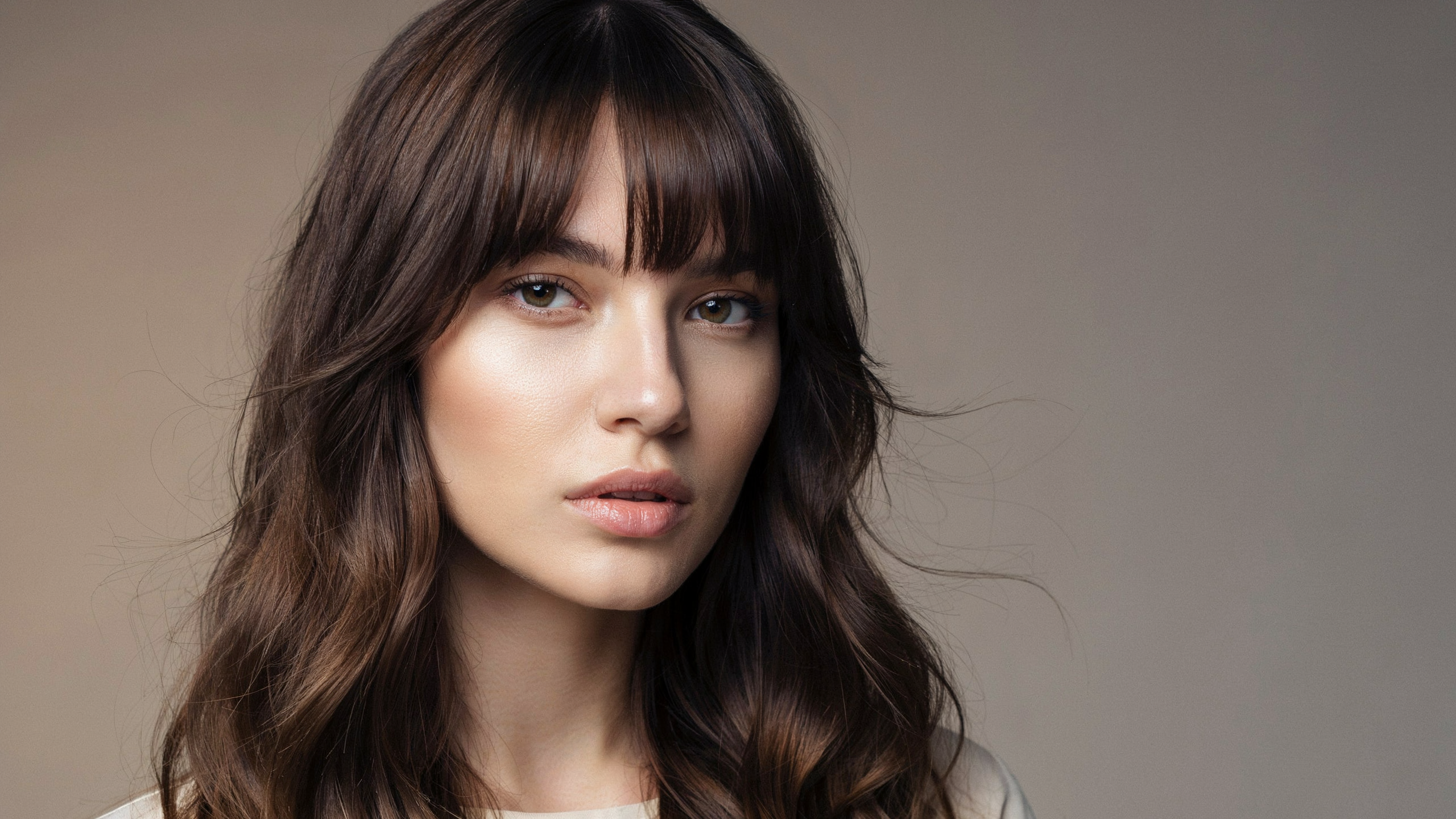Bottleneck fringe haircut fuller at the center and tapering outward at the sides blending into long layers