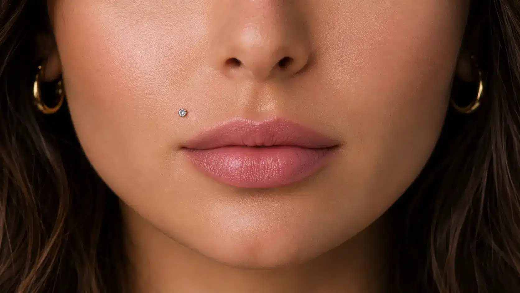 Monroe piercing with a small gemstone stud