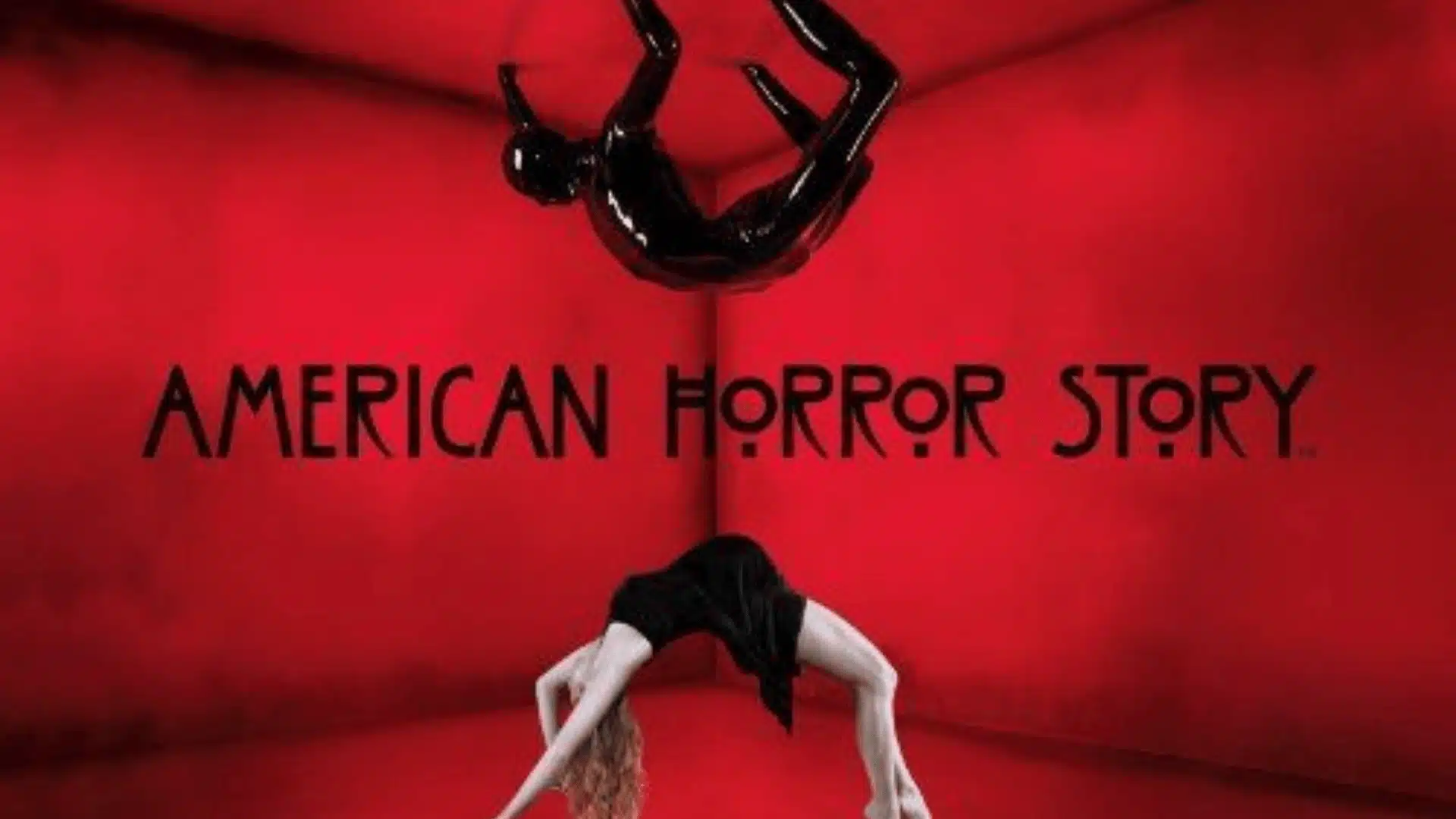 Red room scene from American Horror Story featuring a contorted figure arching on the floor beneath a floating inverted figure.