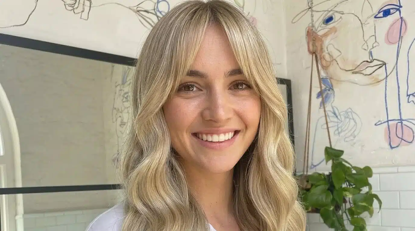 Sheer fringe with light airy strands and soft translucent texture across the forehead in a natural indoor setting