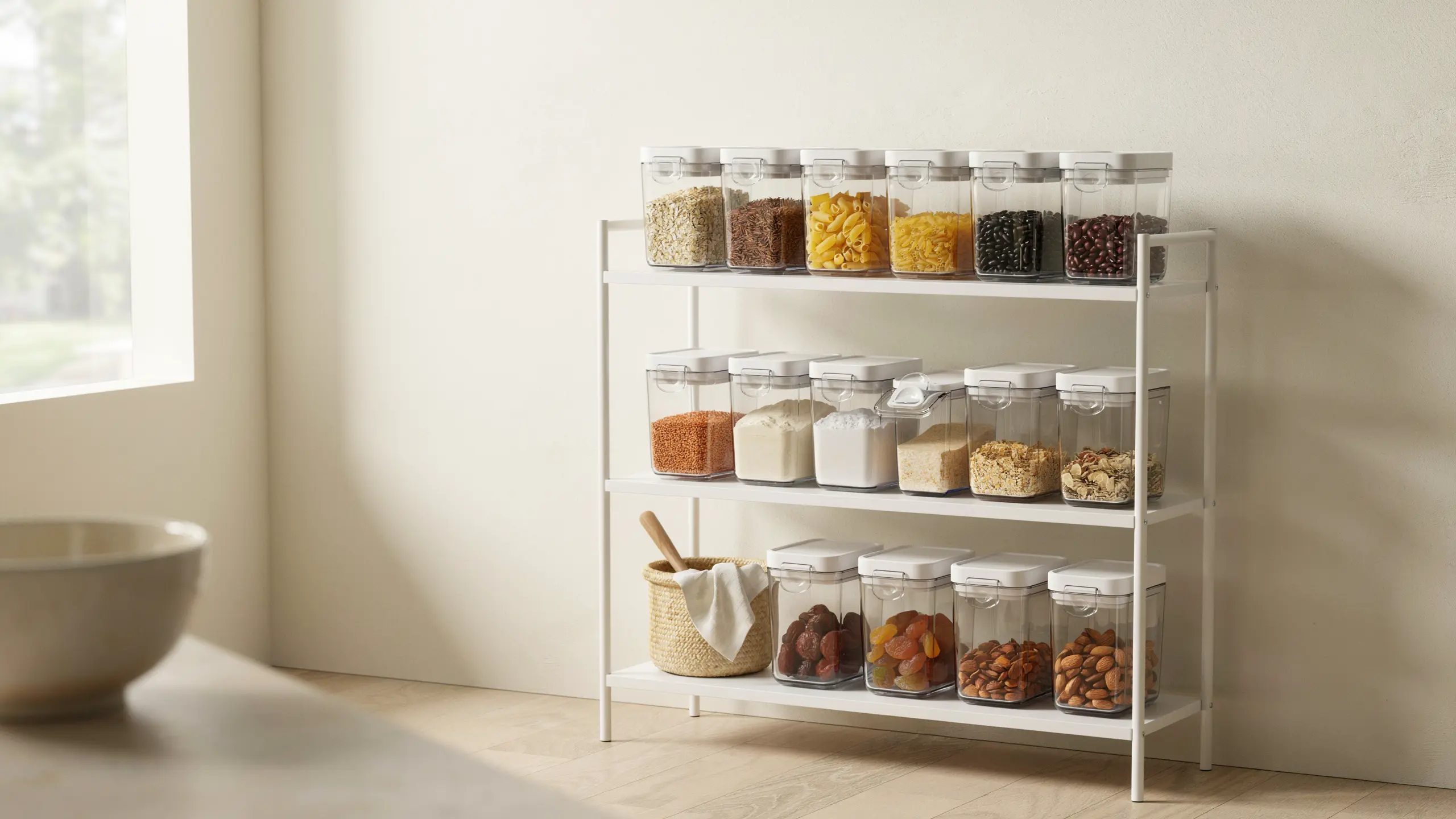 Small pantry with stackable containers storing dry goods neatly.