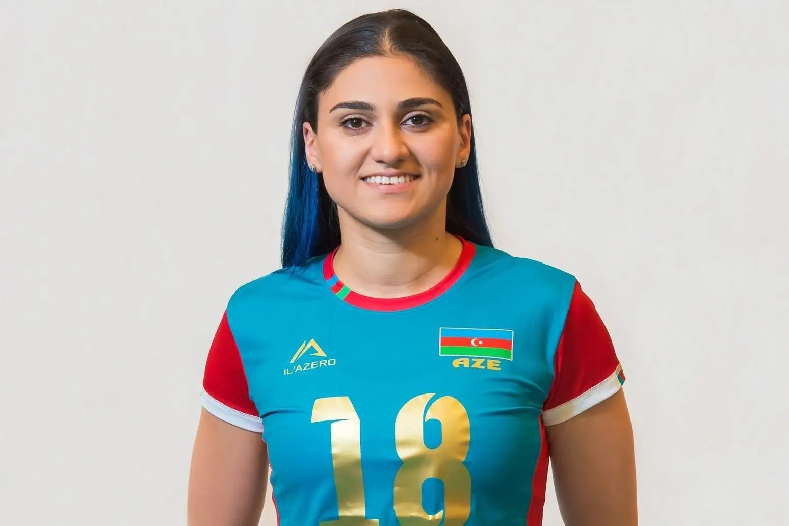 Athlete wearing a blue and red volleyball jersey with Azerbaijan flag and number 18