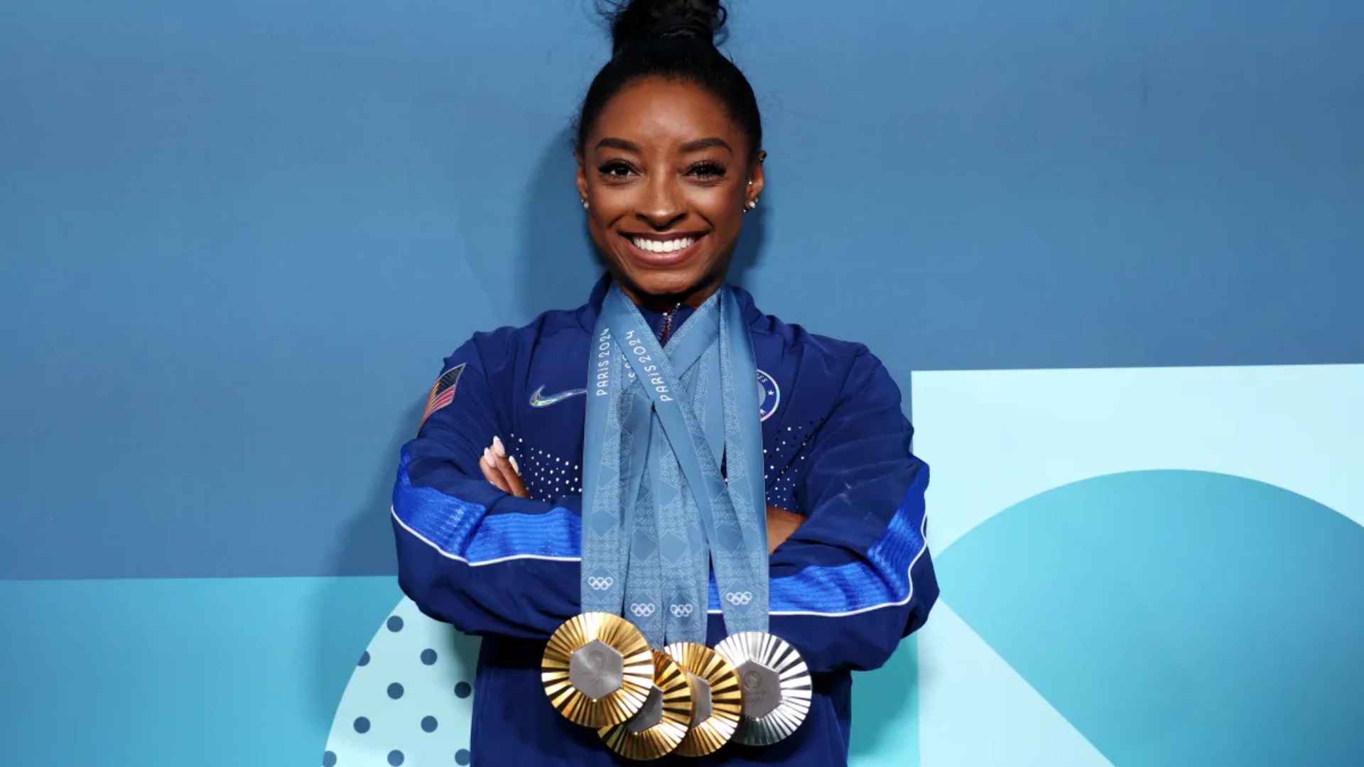 Simone Biles smiling with multiple Olympic medals Paris 2024