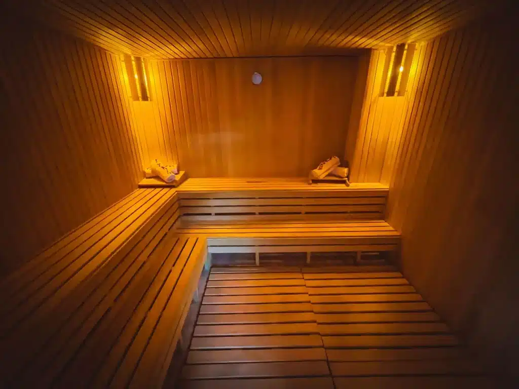 Wooden sauna interior with warm lighting and towels on benches