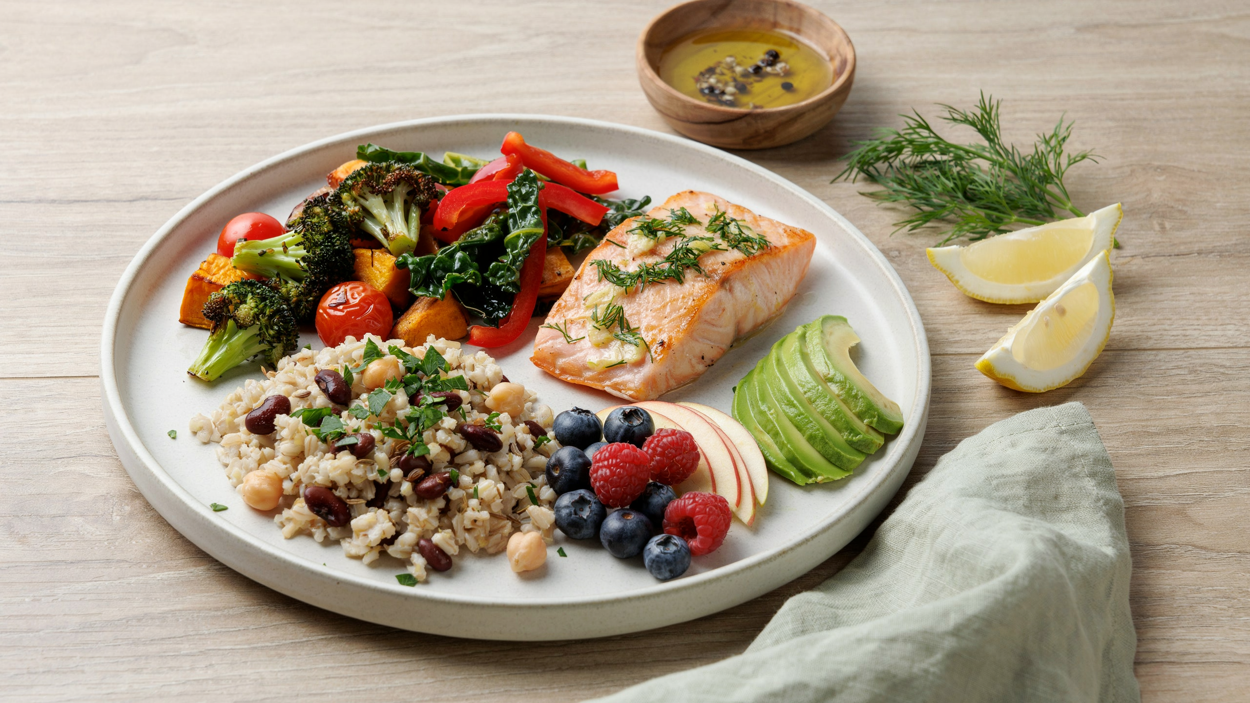 Plate with balanced 80/20 diet showing mostly plant foods, small portion of salmon, fruits, grains, vegetables.