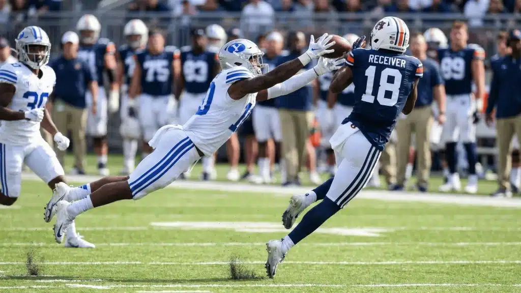 Defensive back leaping to deflect a pass during a football game, demonstrating a Pass Breakup.