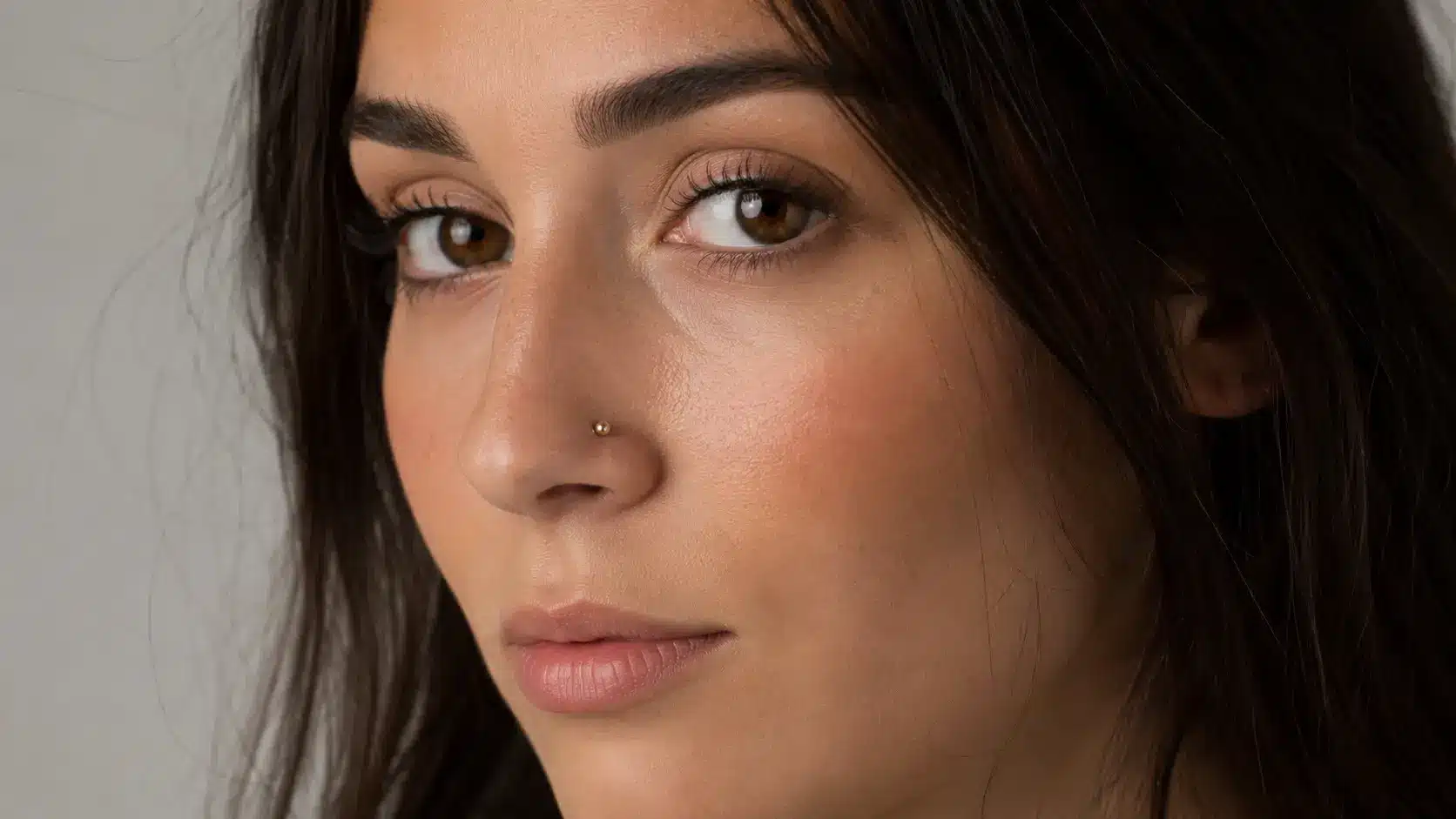 Woman with a small gold nostril stud piercing