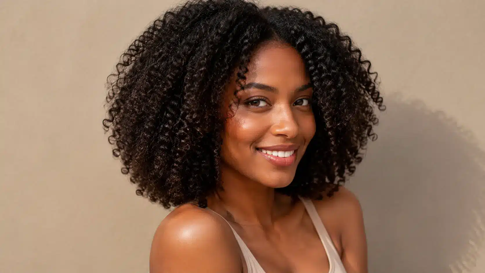 Woman with healthy, dense coily hair and natural texture