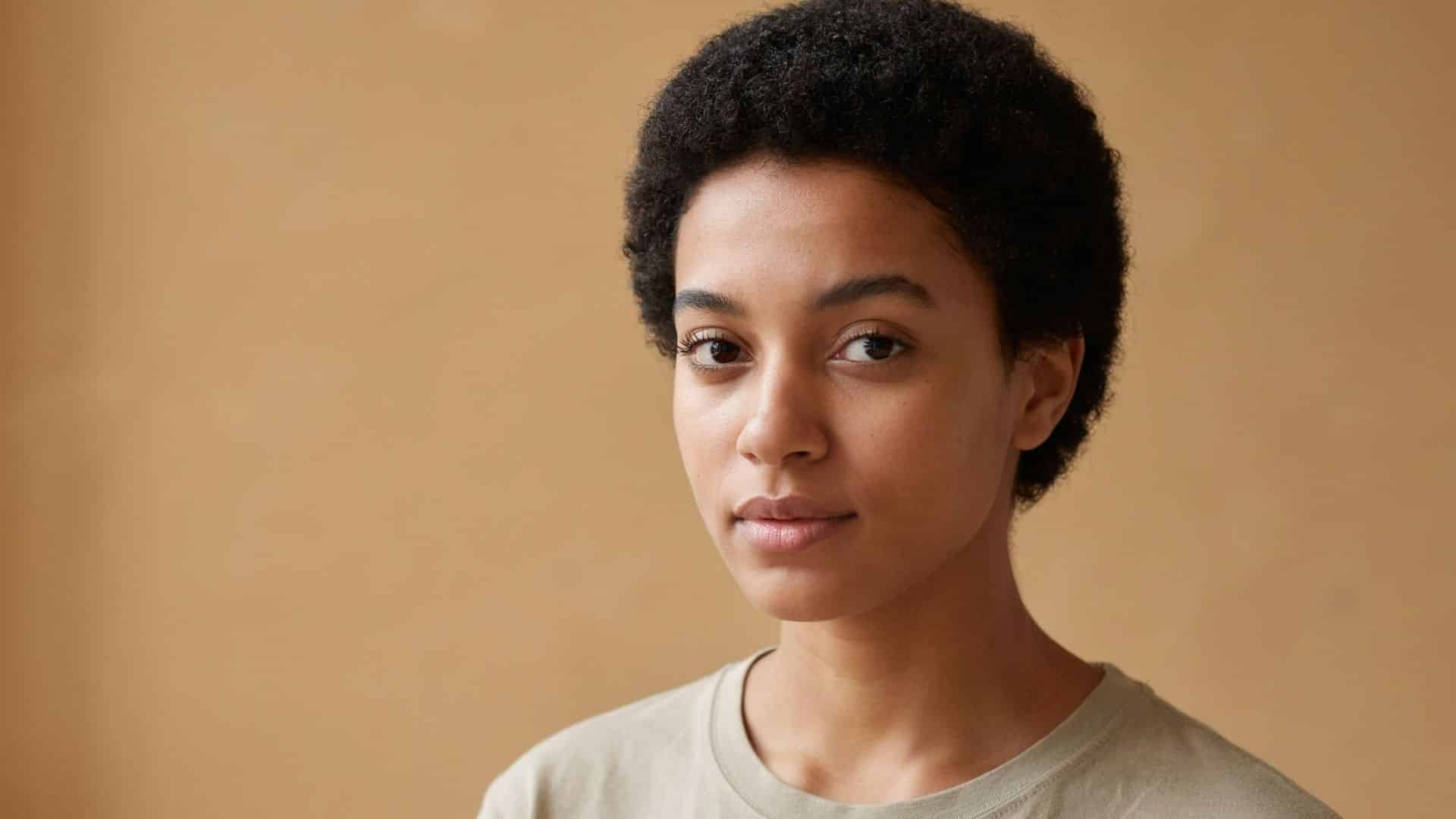 Natural afro crop with tight coils cropped close around the head.