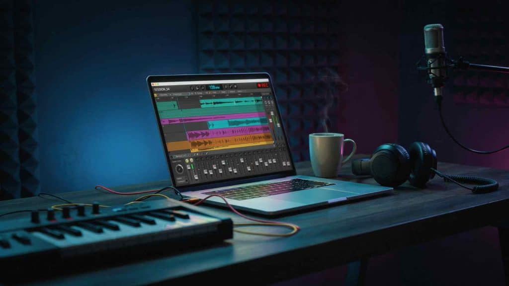 Dark home studio with a glowing DAW interface on a laptop screen and studio headphones on the desk