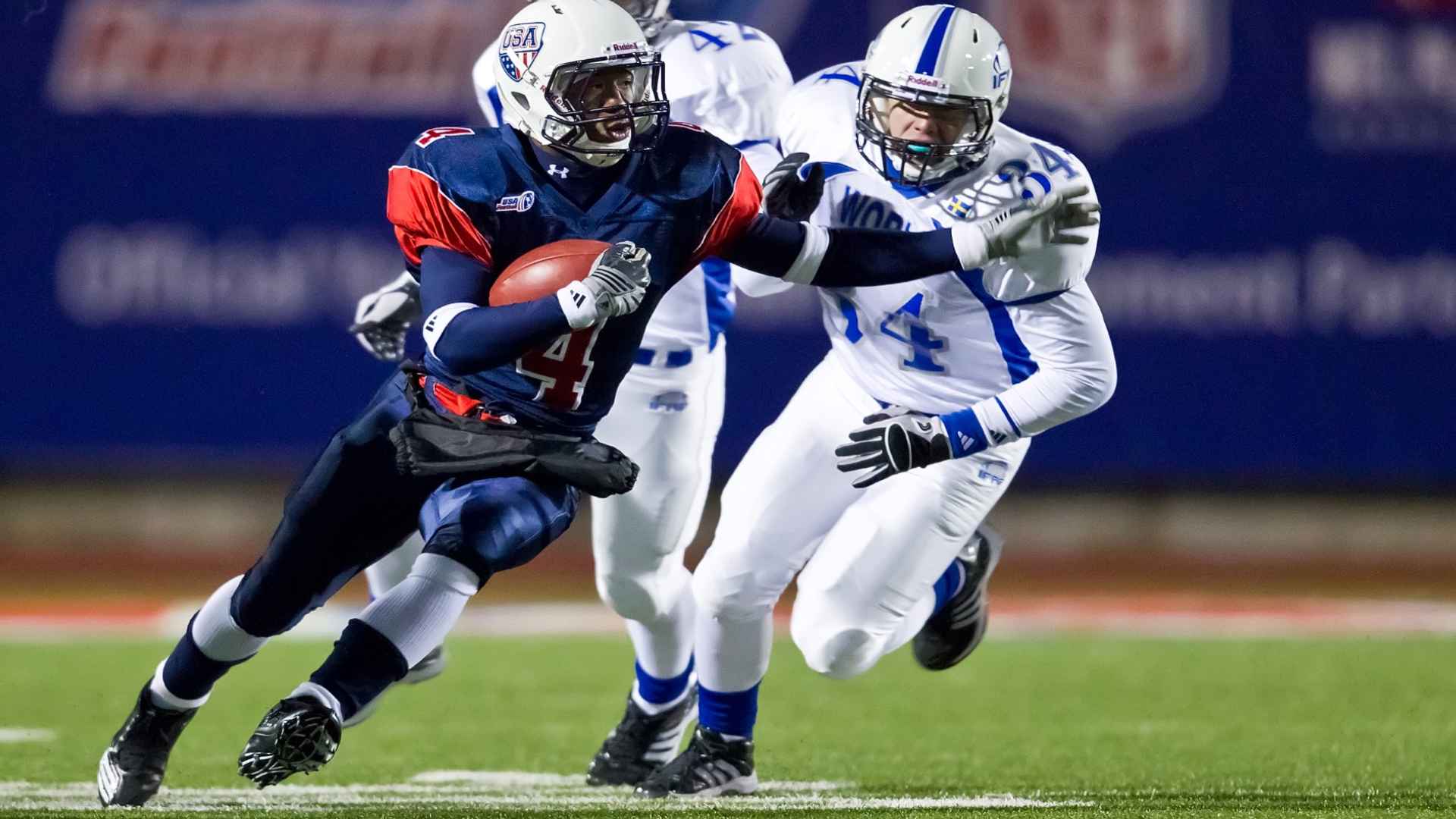 American football play with quarterback and defenders on simple field under soft evening lighting.