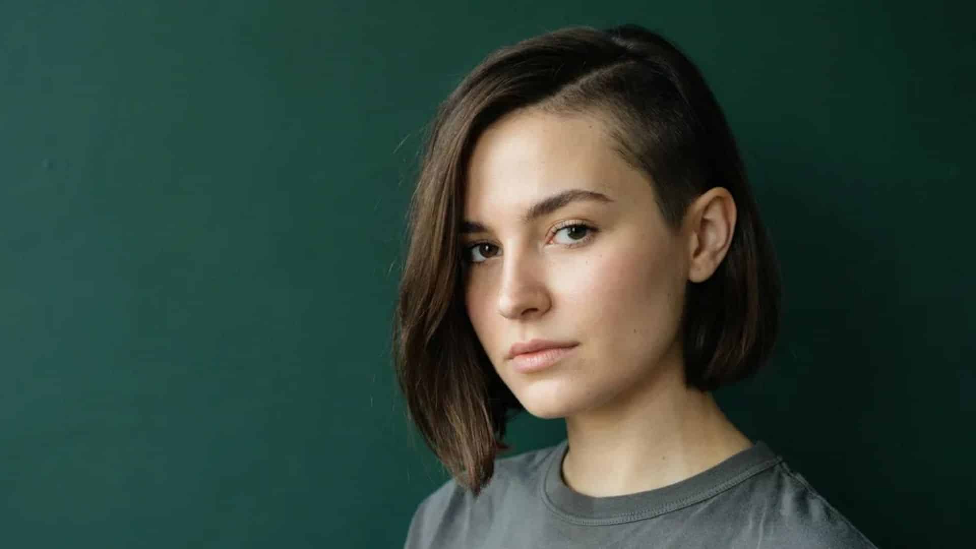 Asymmetrical crop with an undercut side and longer swept-over top.