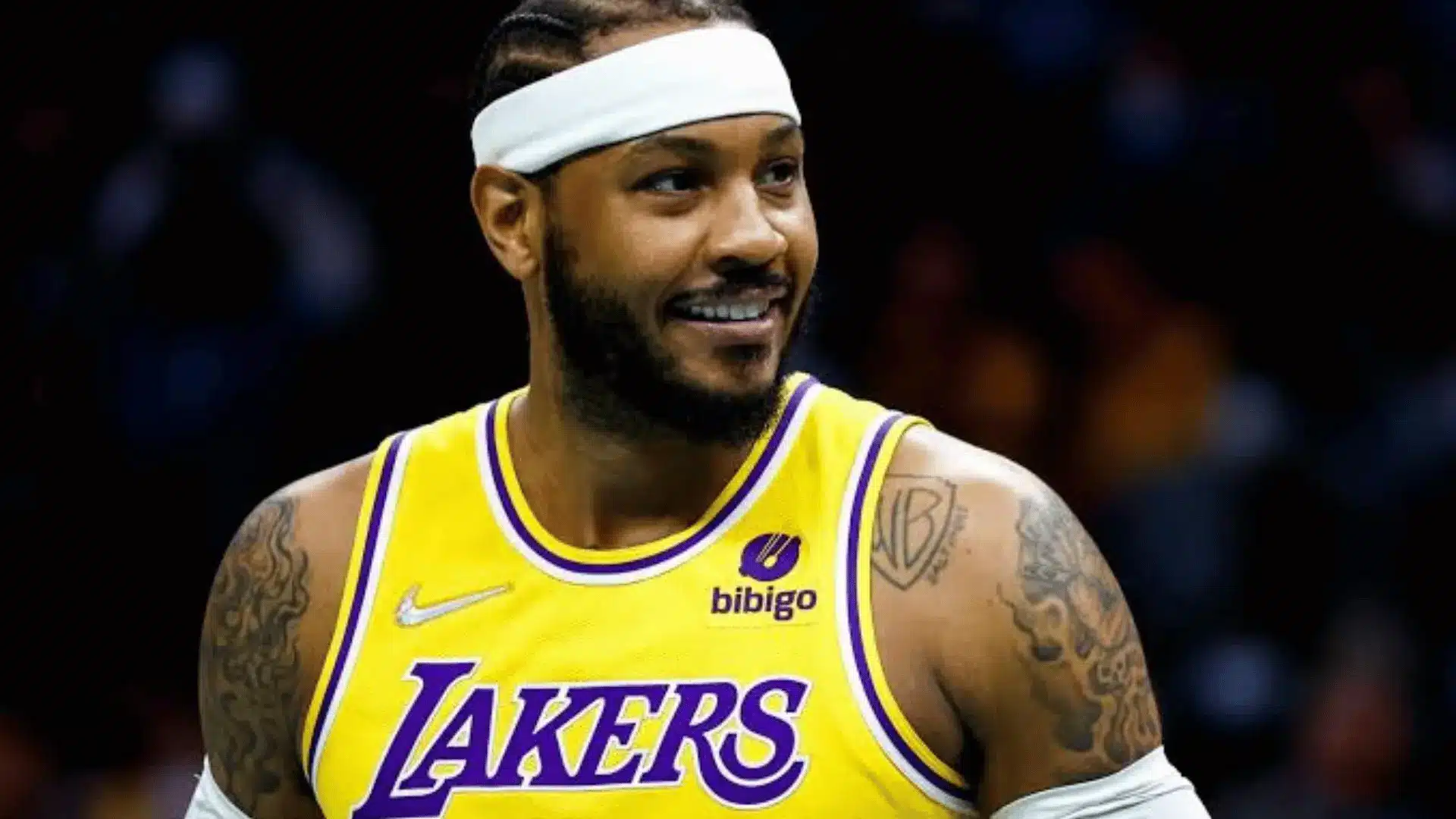 Basketball player wearing a Lakers jersey and headband during a game