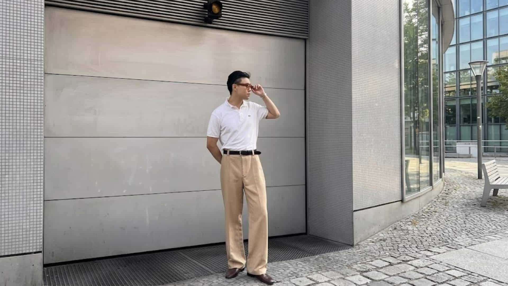Man wearing a white cotton polo shirt with beige chinos and brown loafers in a smart casual outfit