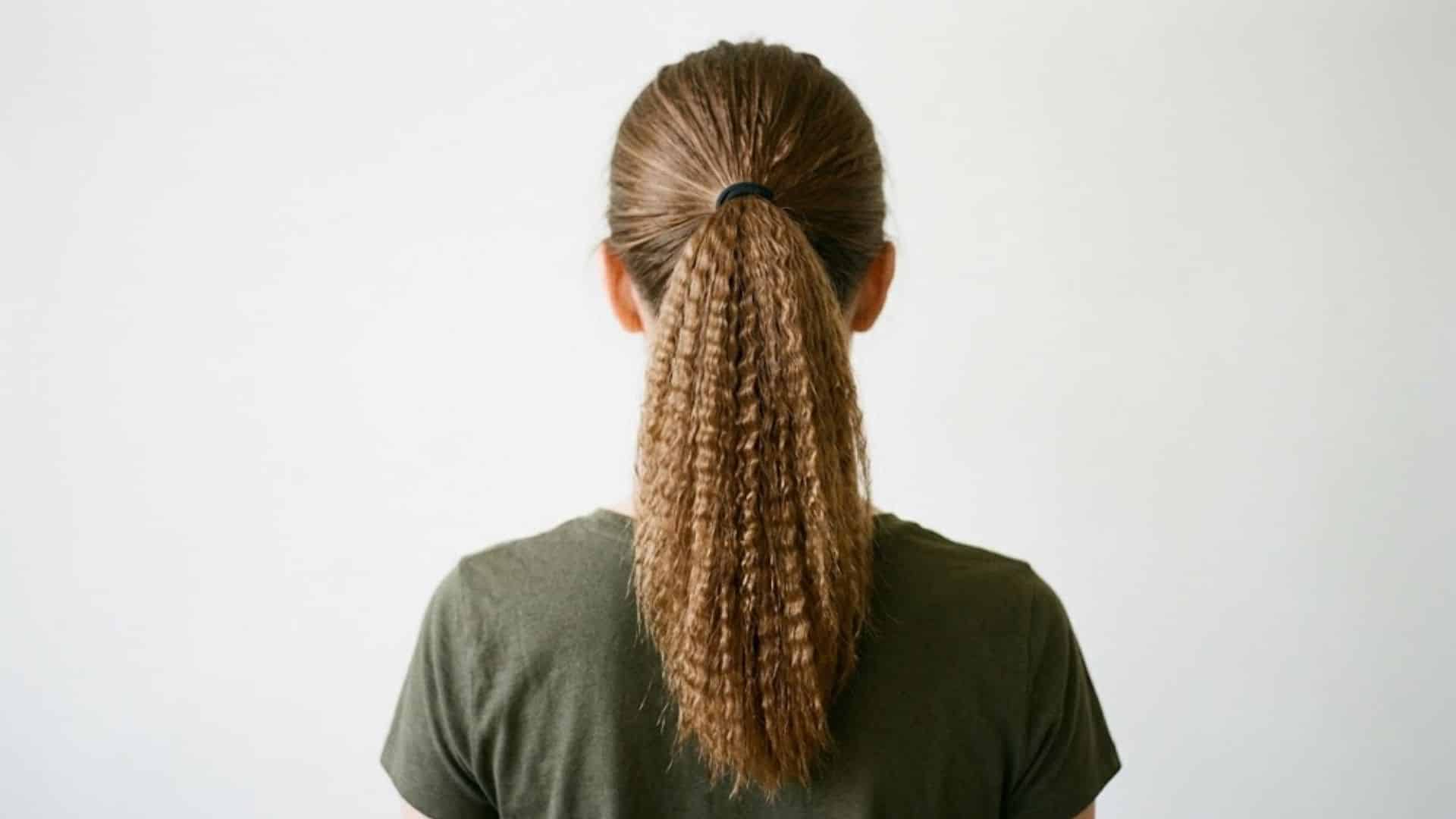 Back view of a low ponytail with crimped, textured hair strands