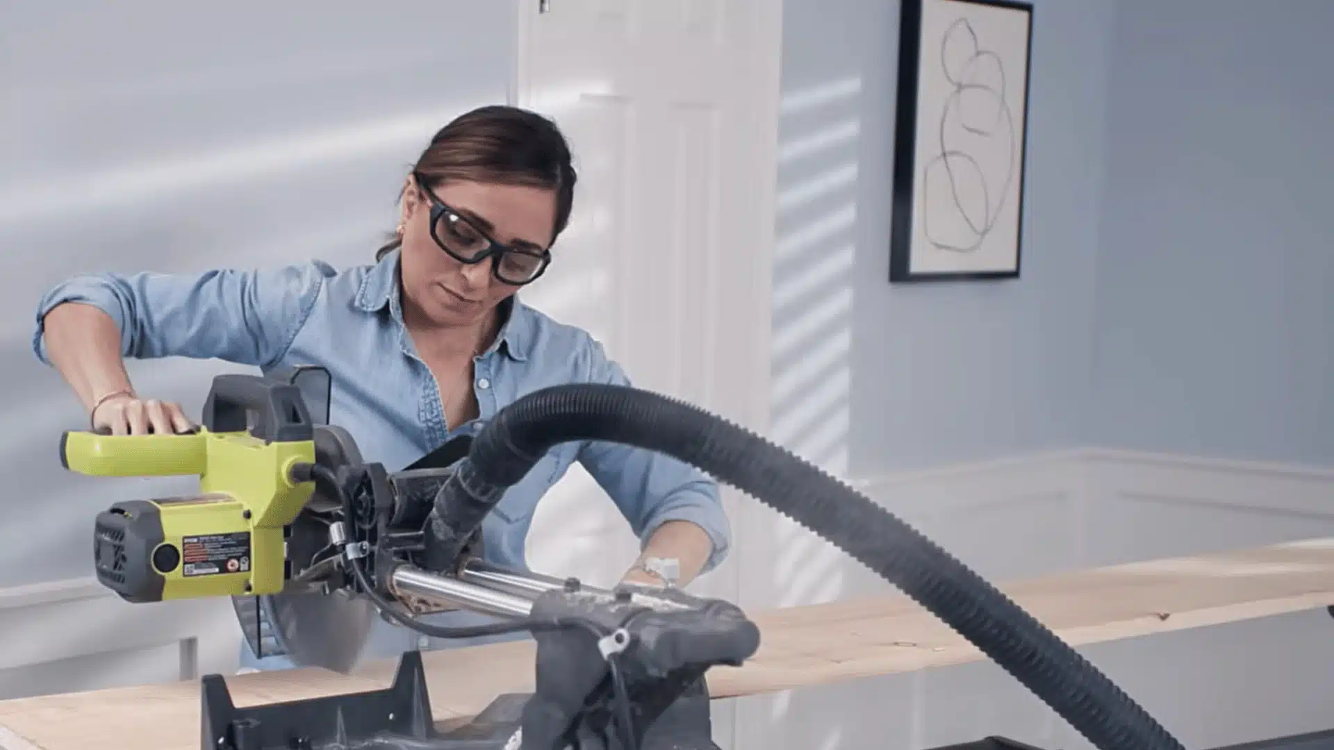 Person using a power saw to cut a wooden board during a home improvement project