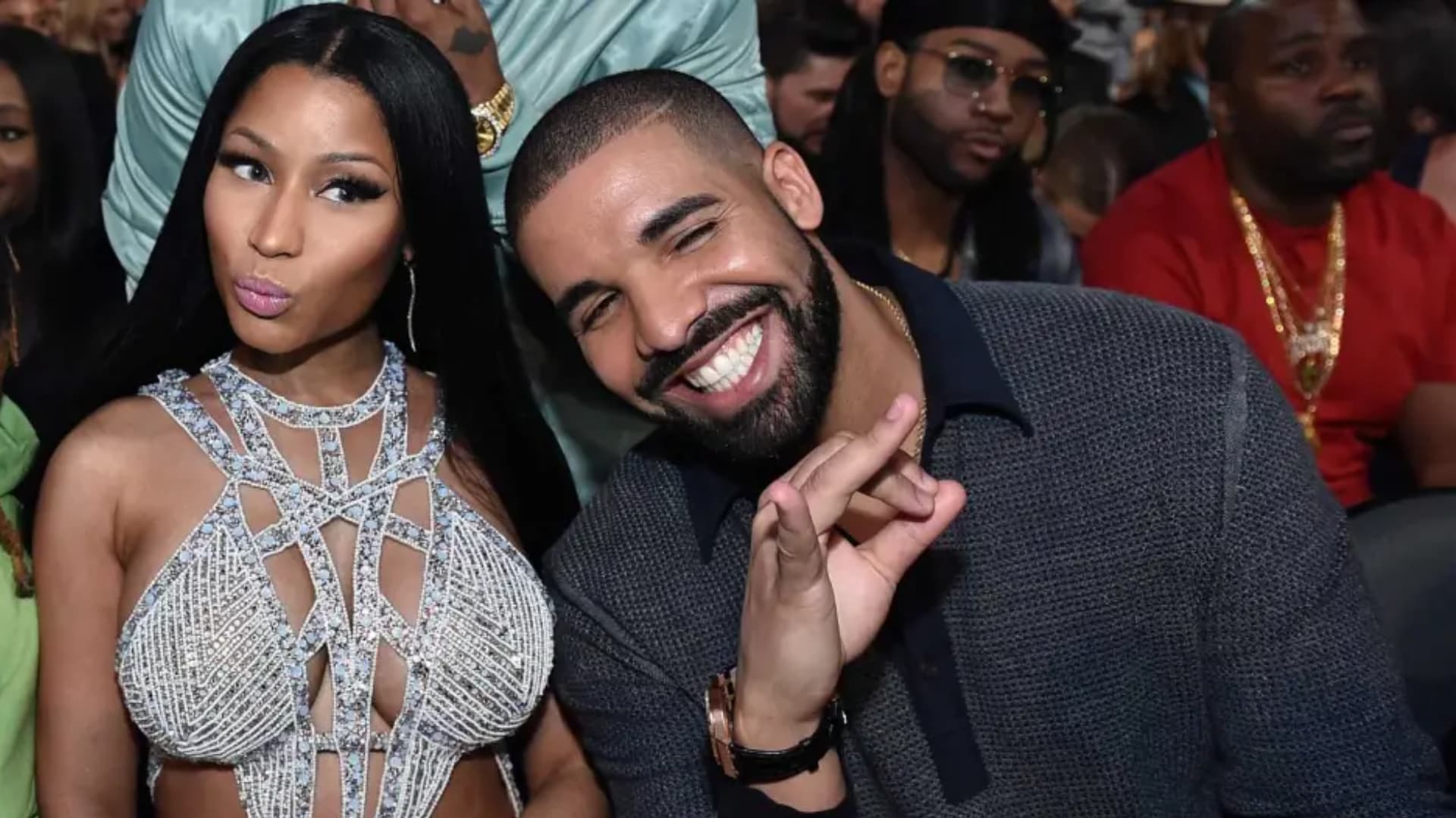 Nicki Minaj and Drake smiling together at an awards event, both dressed in formal attire