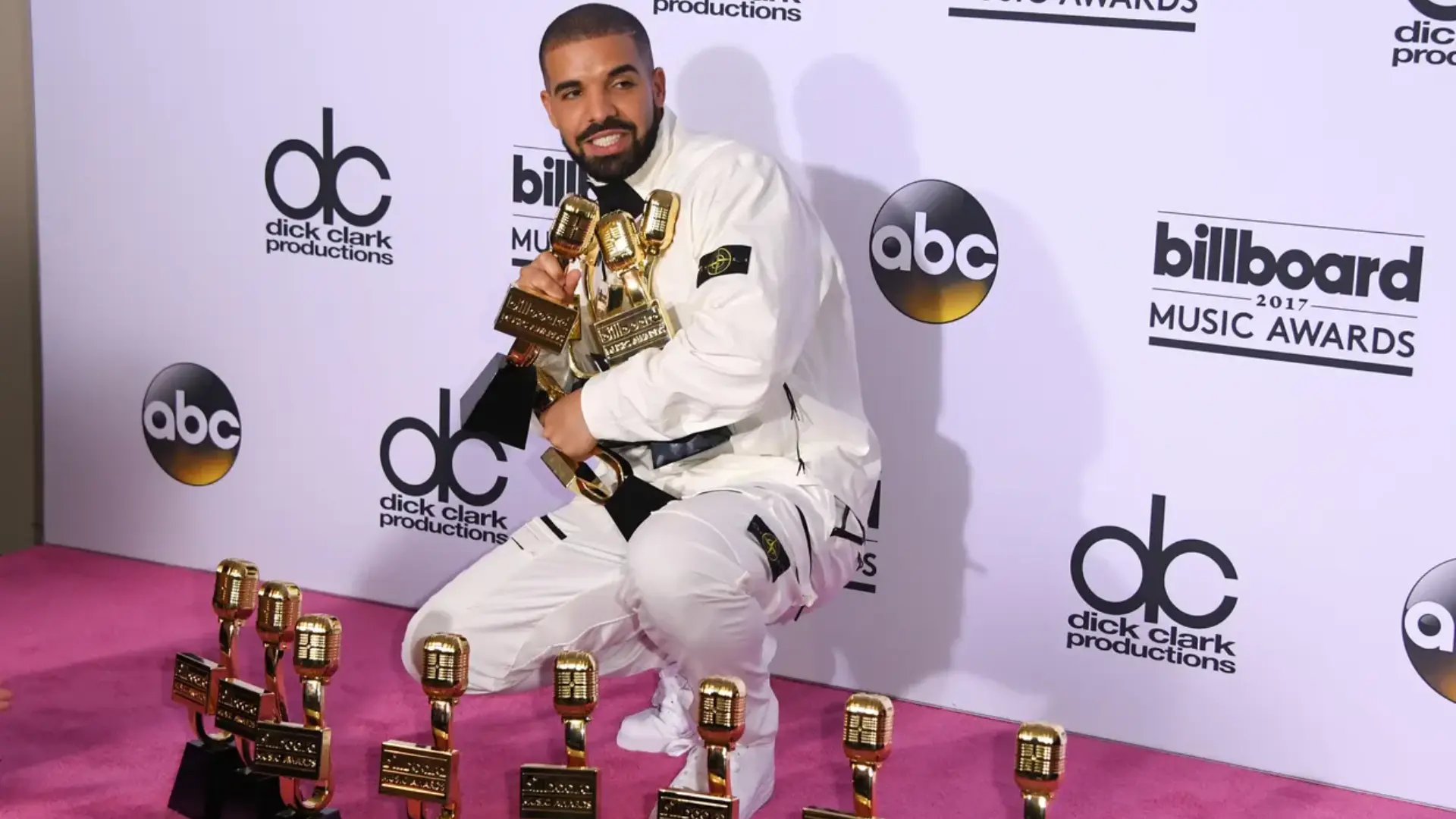 Drake posing with multiple trophies at the 2017 Billboard Music Awards press room