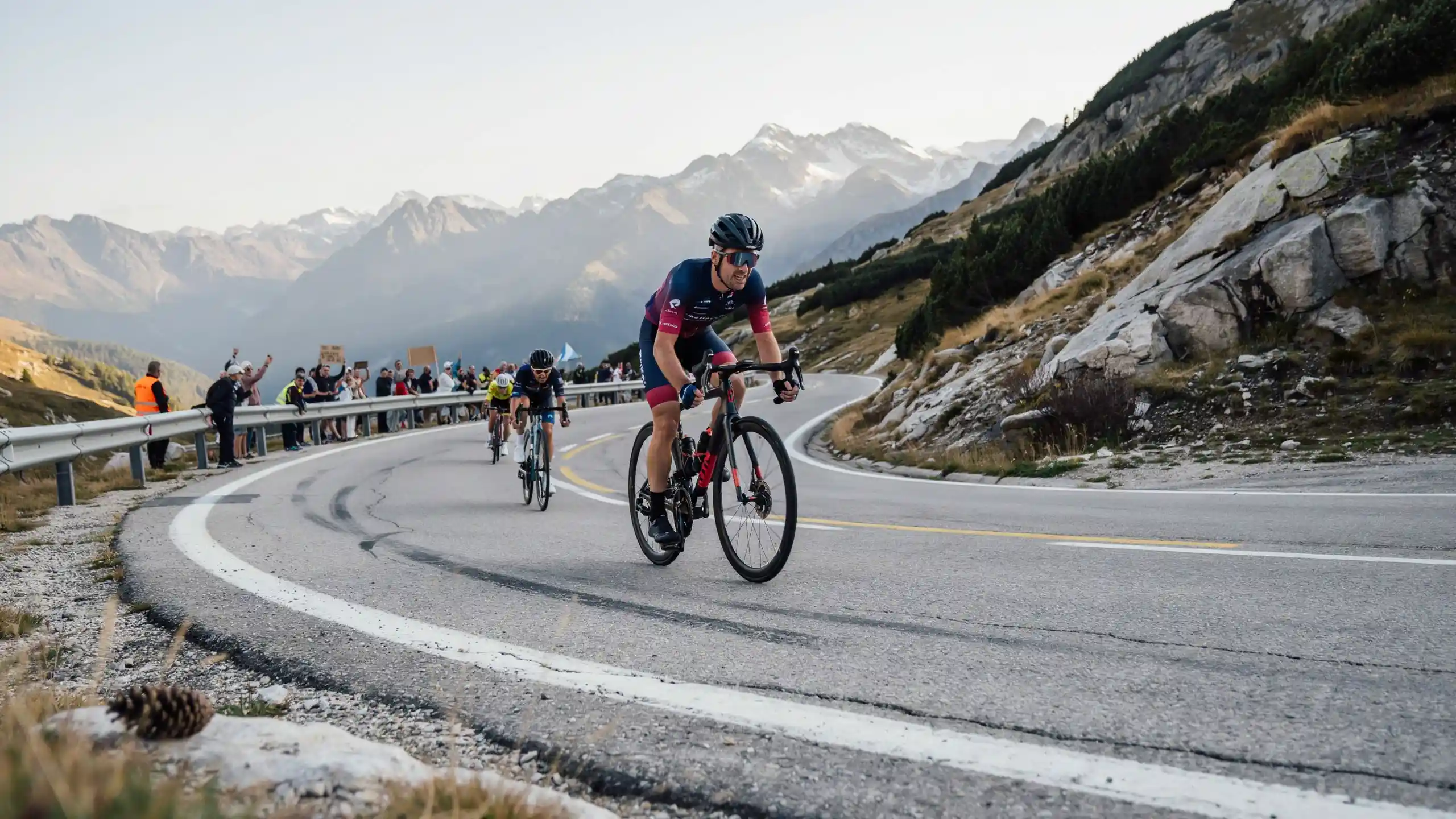 Cyclists racing uphill on a mountain road during an endurance cycling event with scenic peaks in the background