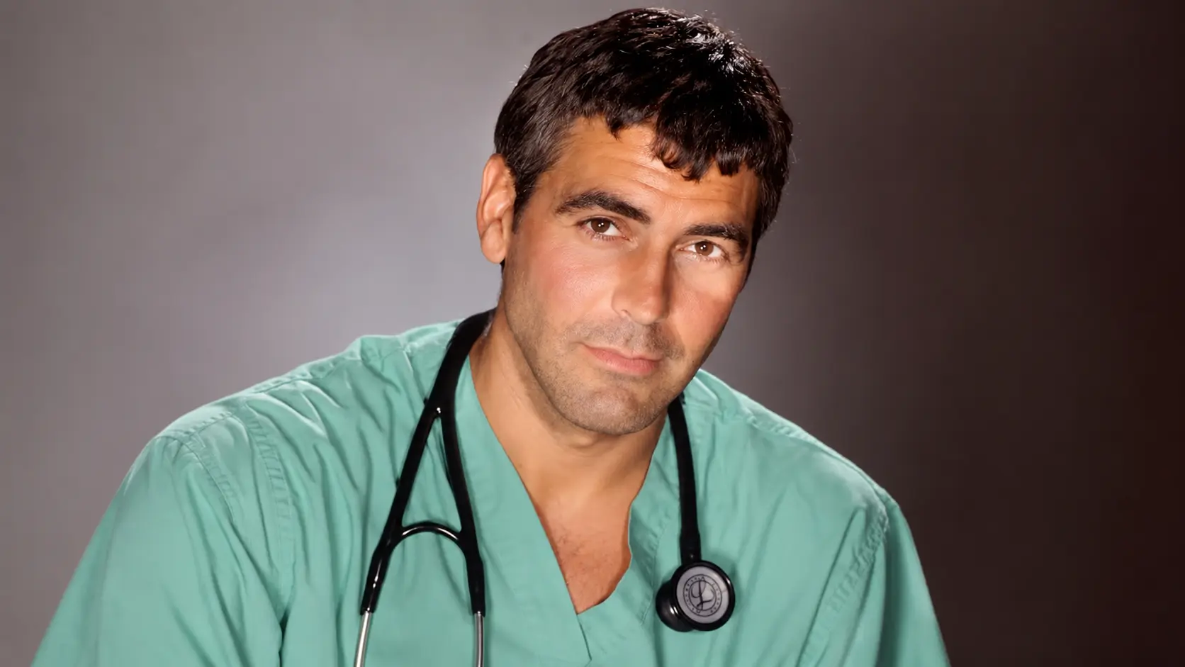 George clooney wearing medical scrubs with a short textured haircut and neat fringe in a professional studio portrait