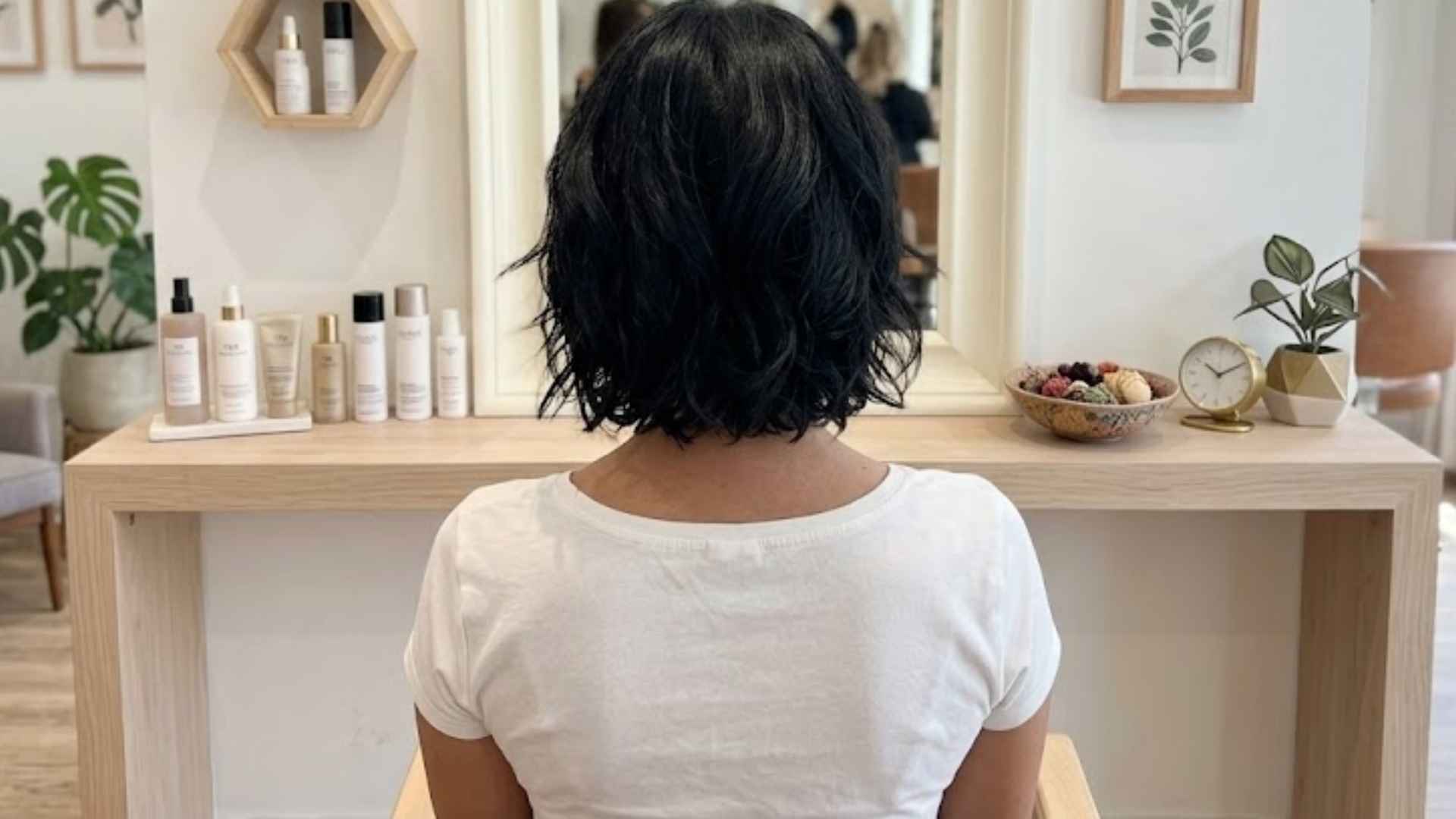 Woman with a glass hair layered bob featuring ultra-shiny smooth layers and reflective finish.