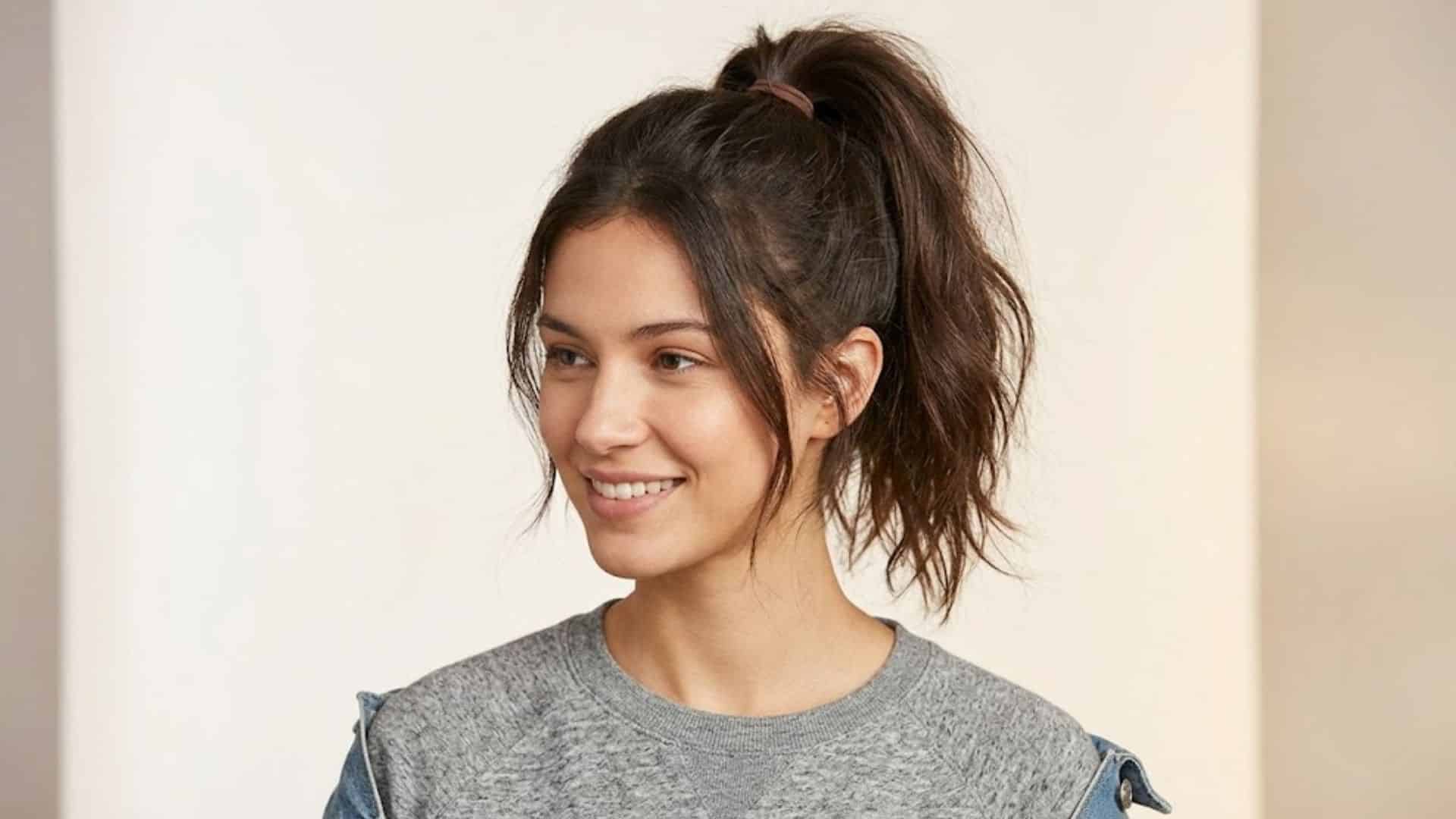 Woman with a tousled high casual ponytail and loose face-framing pieces
