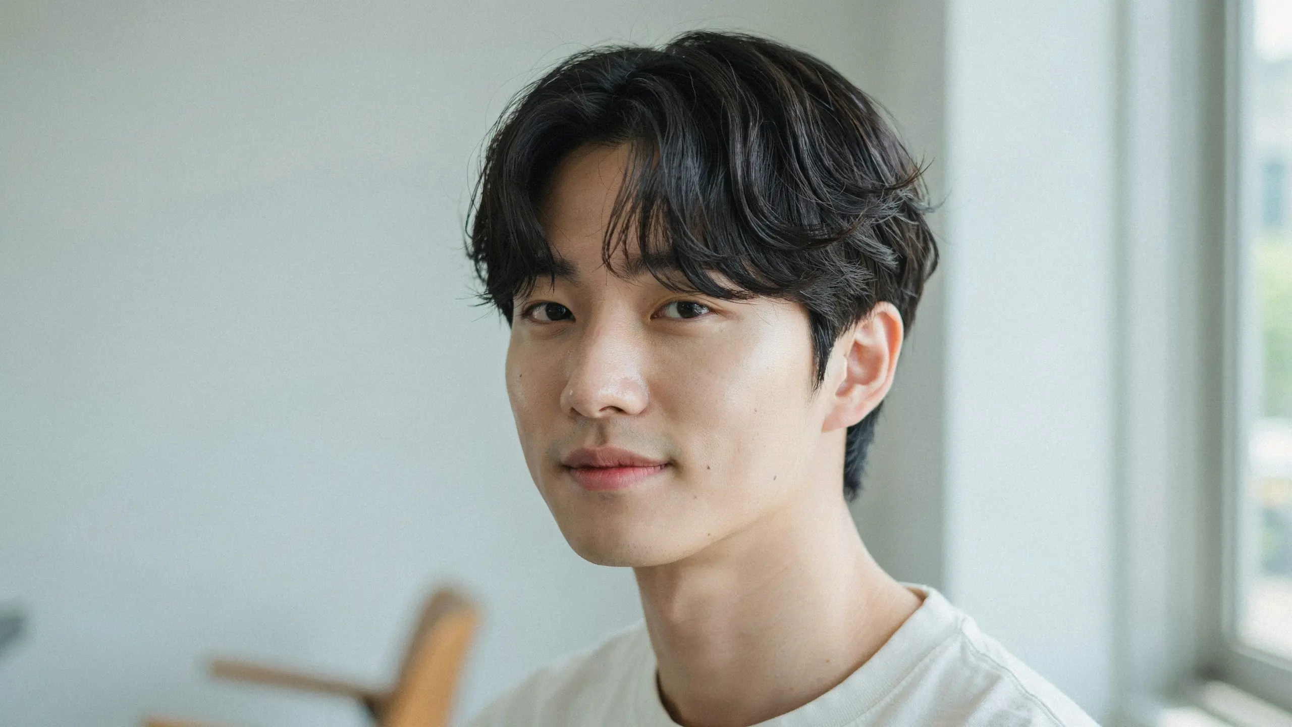 Man with a Korean wave perm showing loose S-shaped waves, soft texture, and effortless volume for medium-length hair.