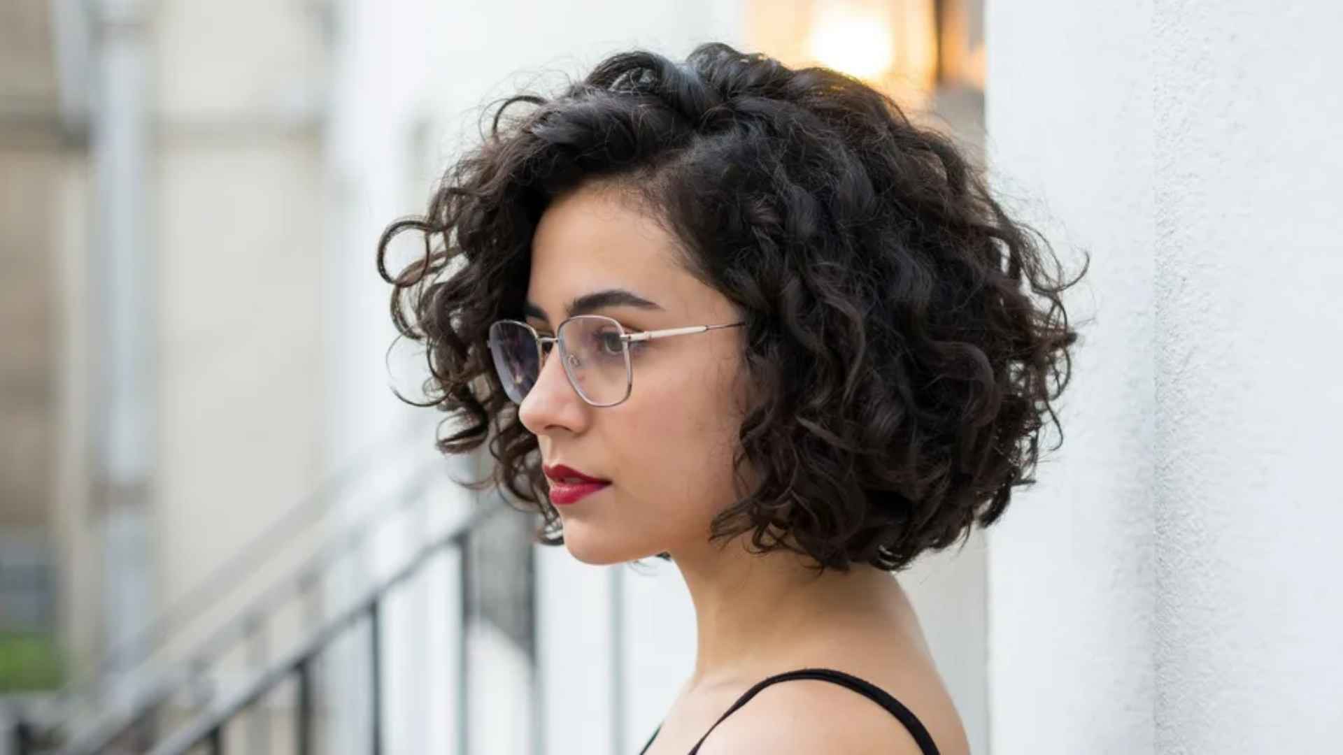 Woman with a layered bob for fine curly hair featuring soft curls and fuller appearance.
