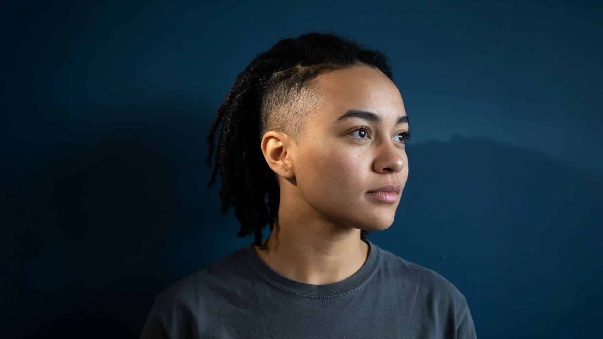 Locs with undercut, shaved side detailing and locs pulled back neatly.