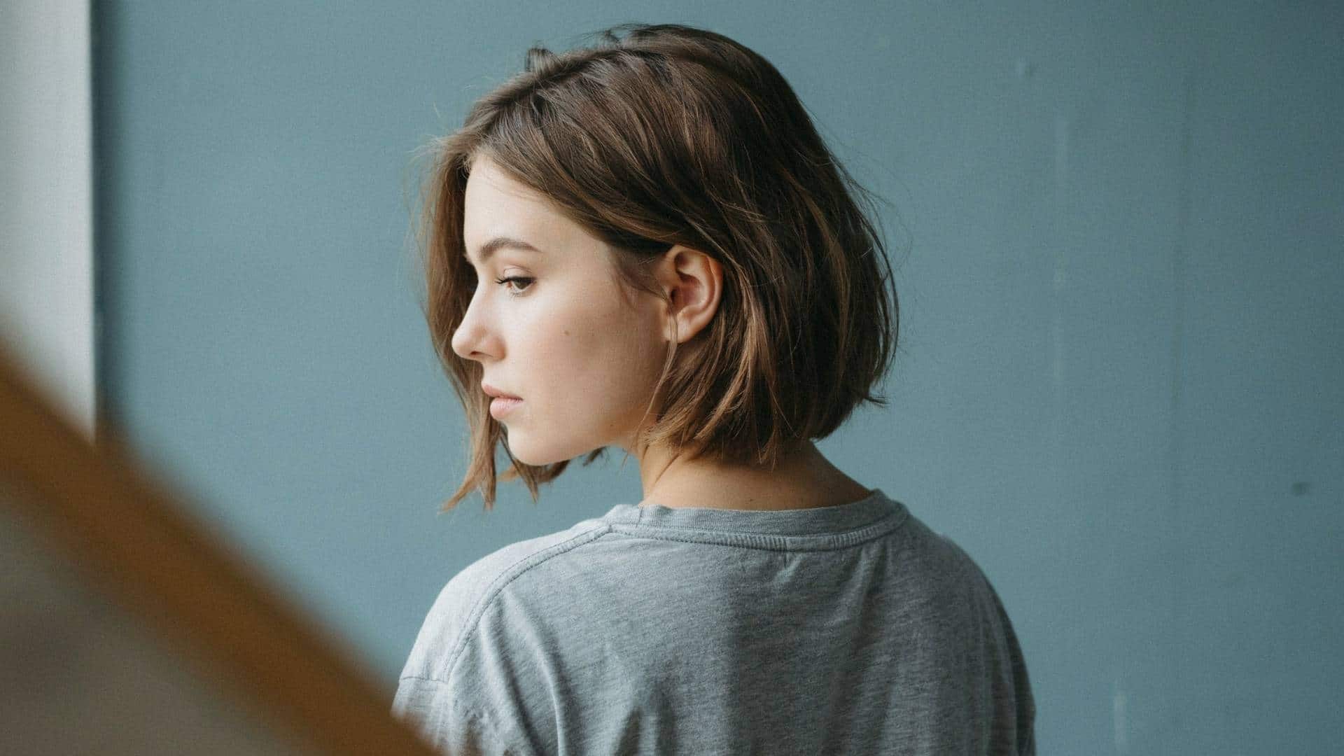 Side profile of a long pixie cut, soft waves framing the jaw and neck.